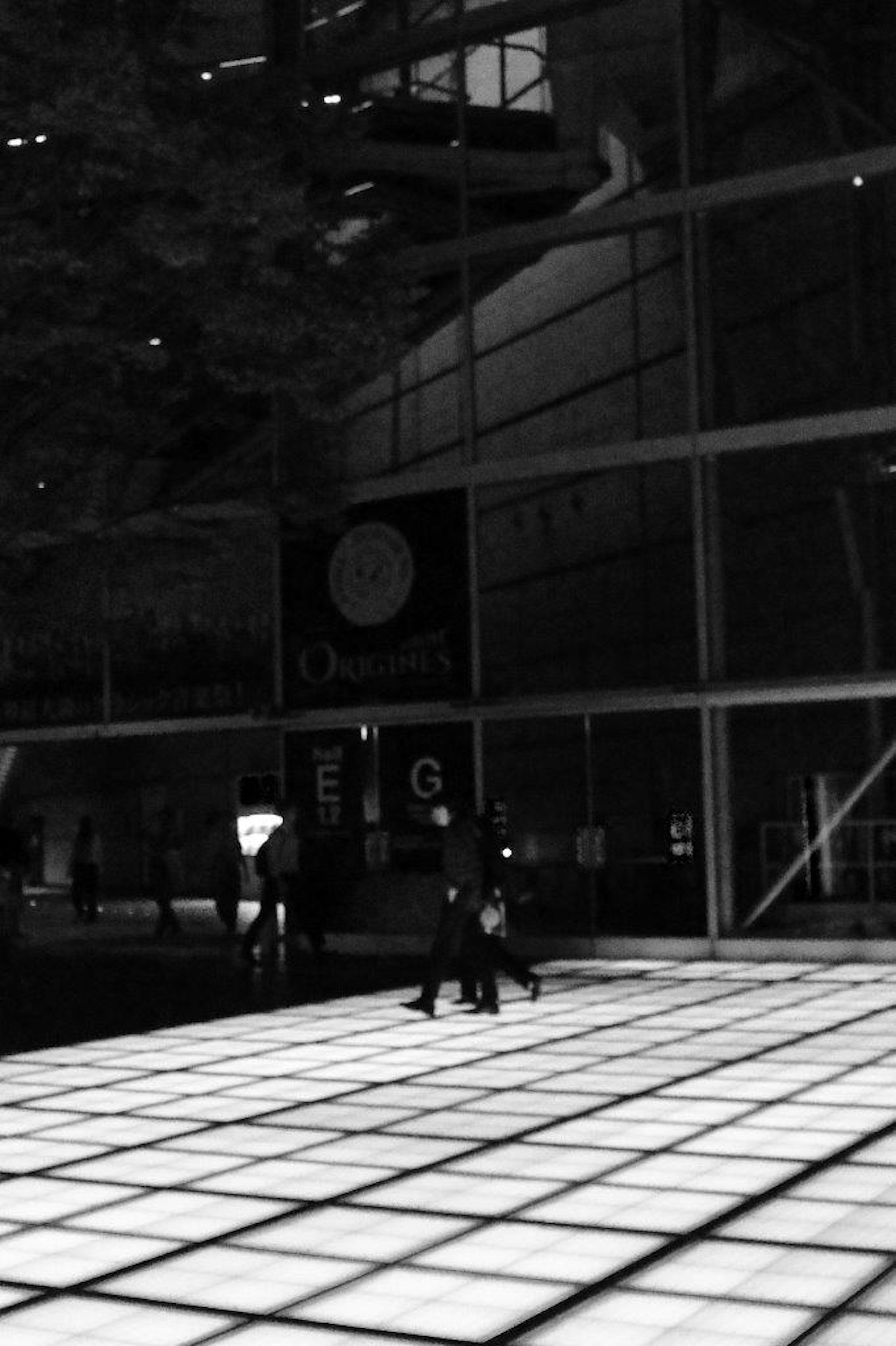 Contrasting black and white urban scene people walking on glass floor