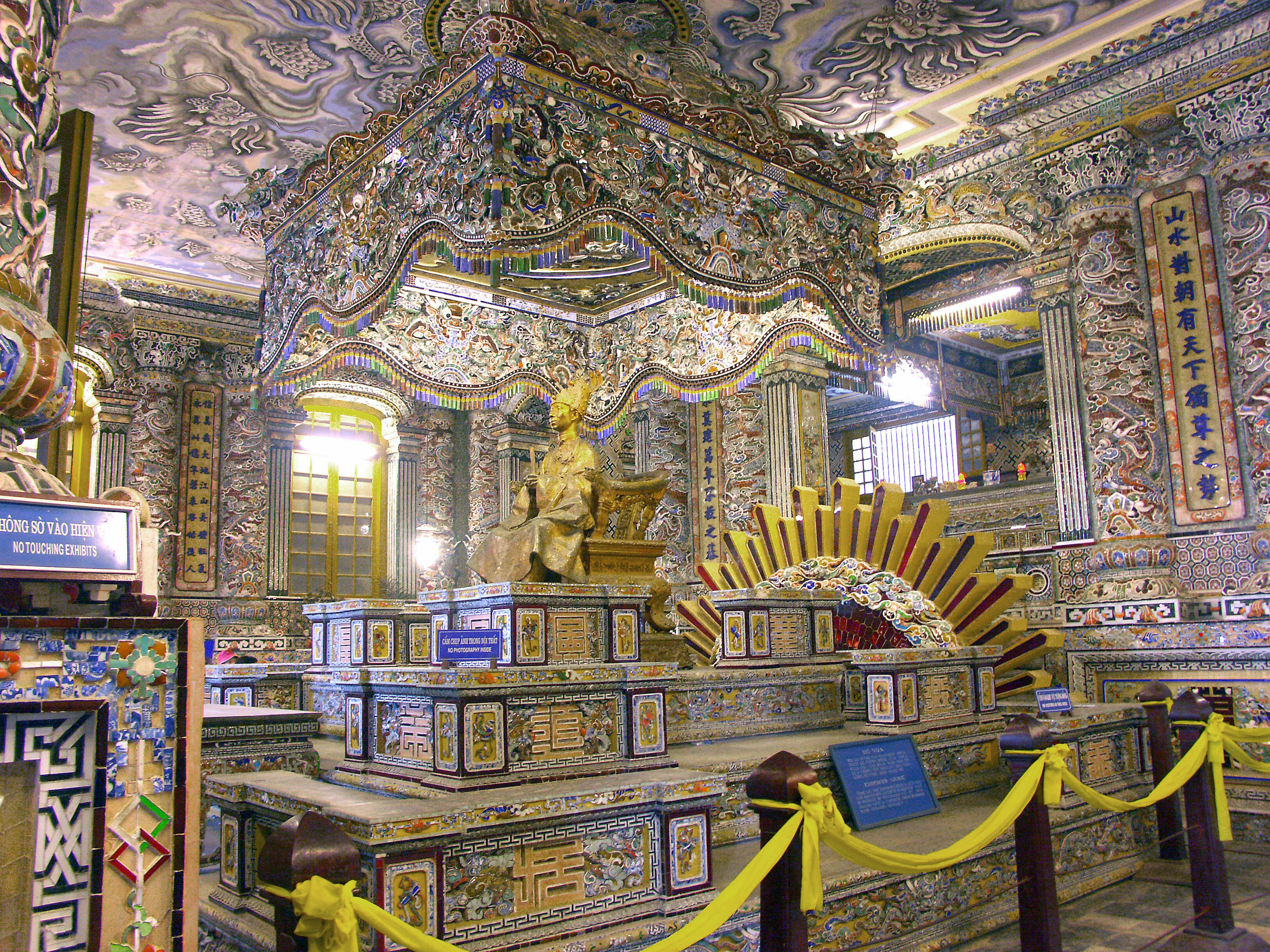 Interior of a decorated Buddhist temple featuring a golden statue and colorful walls