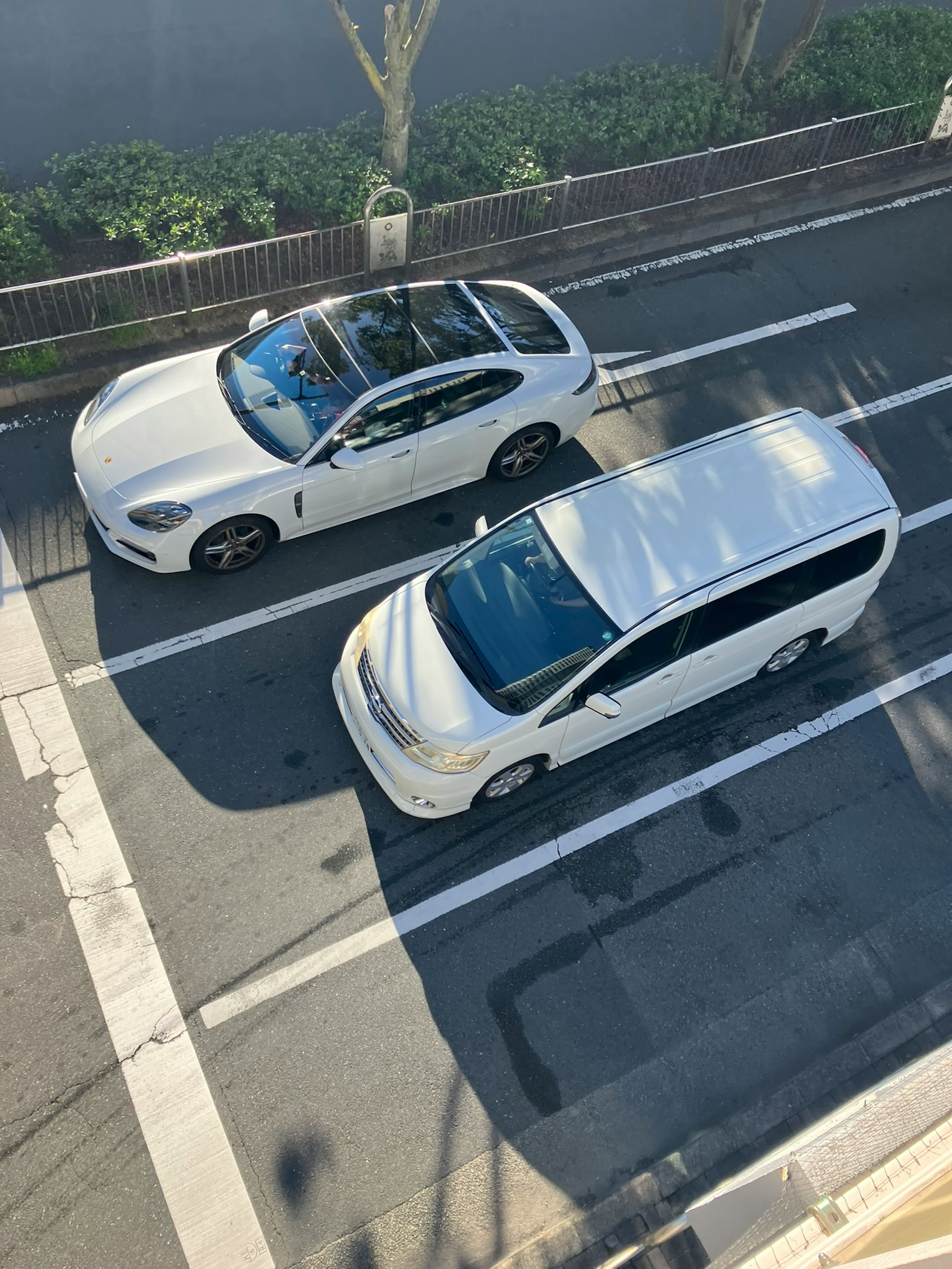 Vue aérienne de deux voitures blanches se croisant sur une route