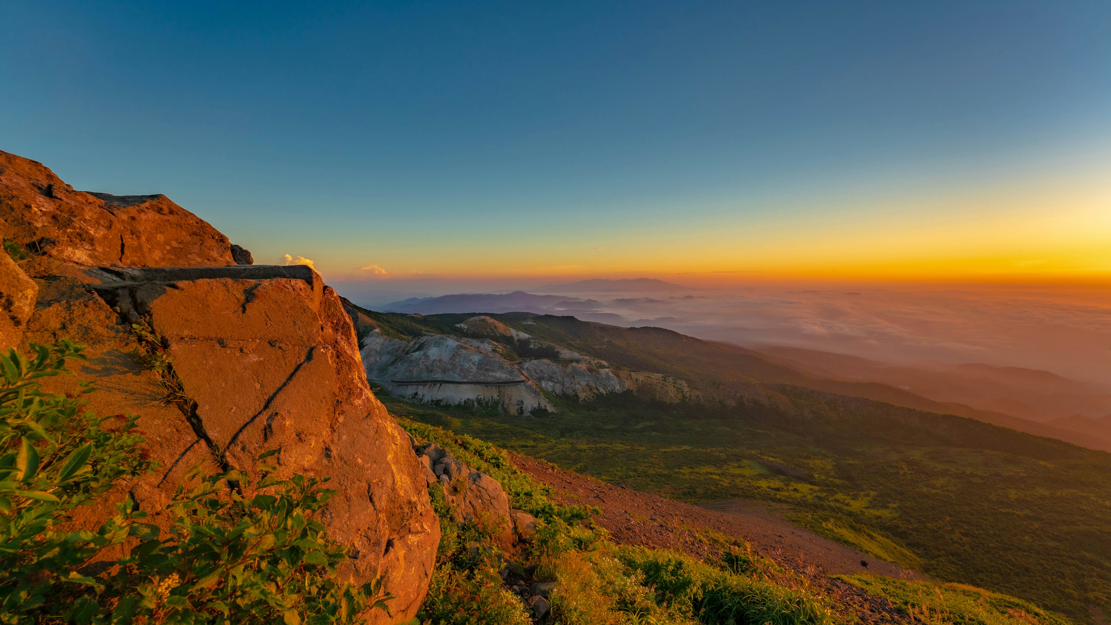 Malersiche Aussicht auf eine Berglandschaft mit roten Felsen und einem schönen Sonnenuntergang