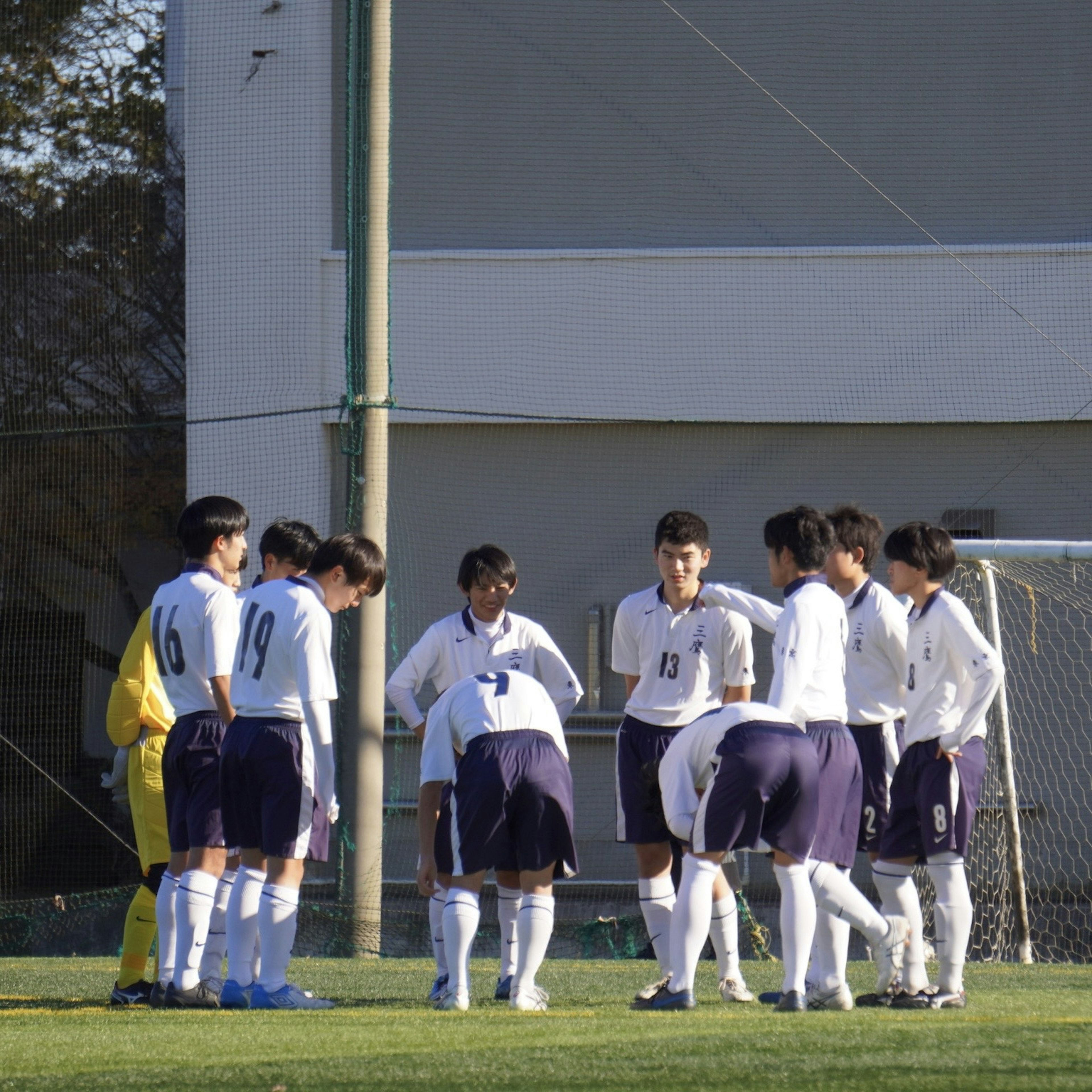 Equipo de fútbol discutiendo estrategias en el campo