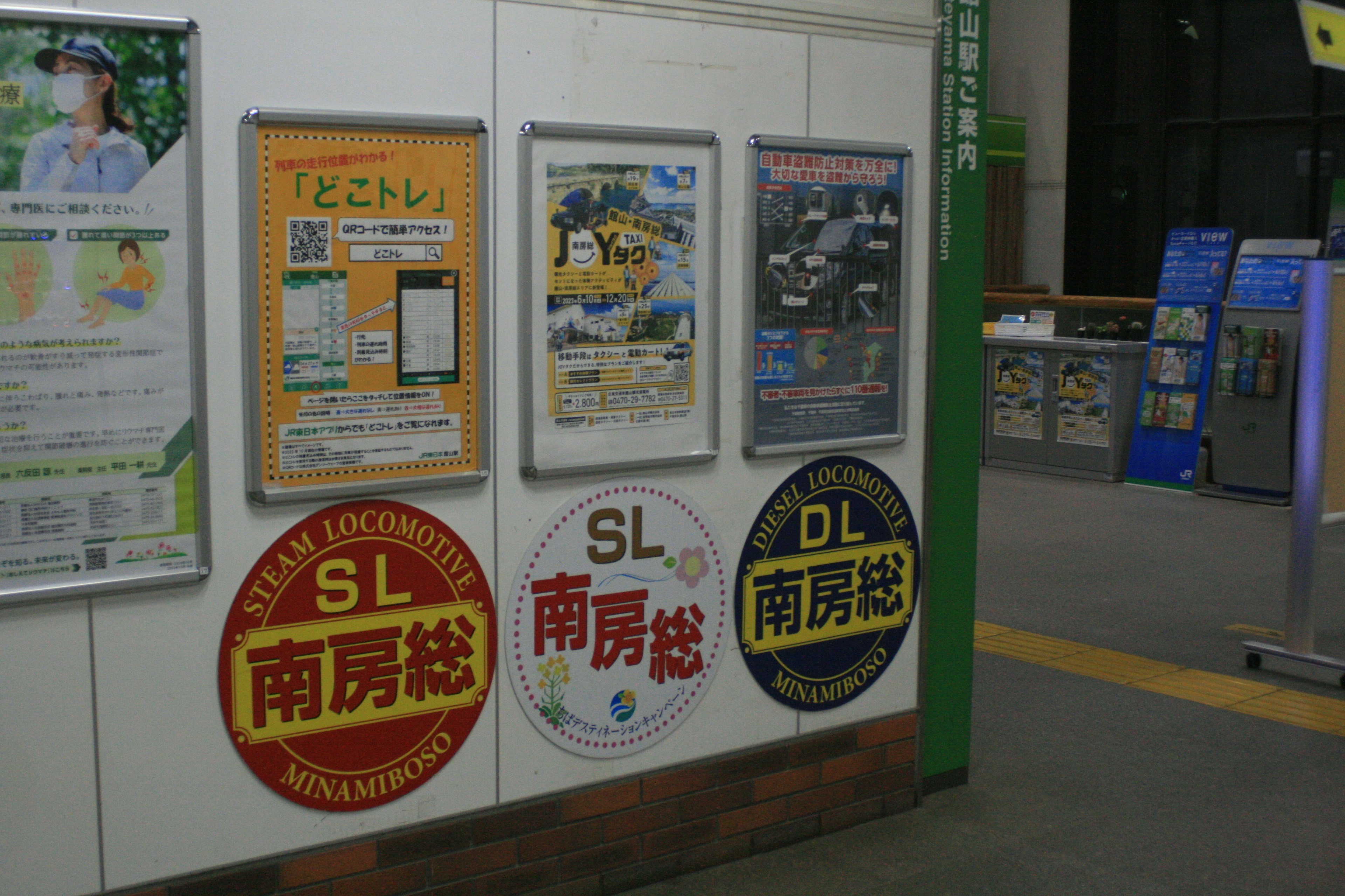 Pubblicità e poster informativi esposti su un muro della stazione