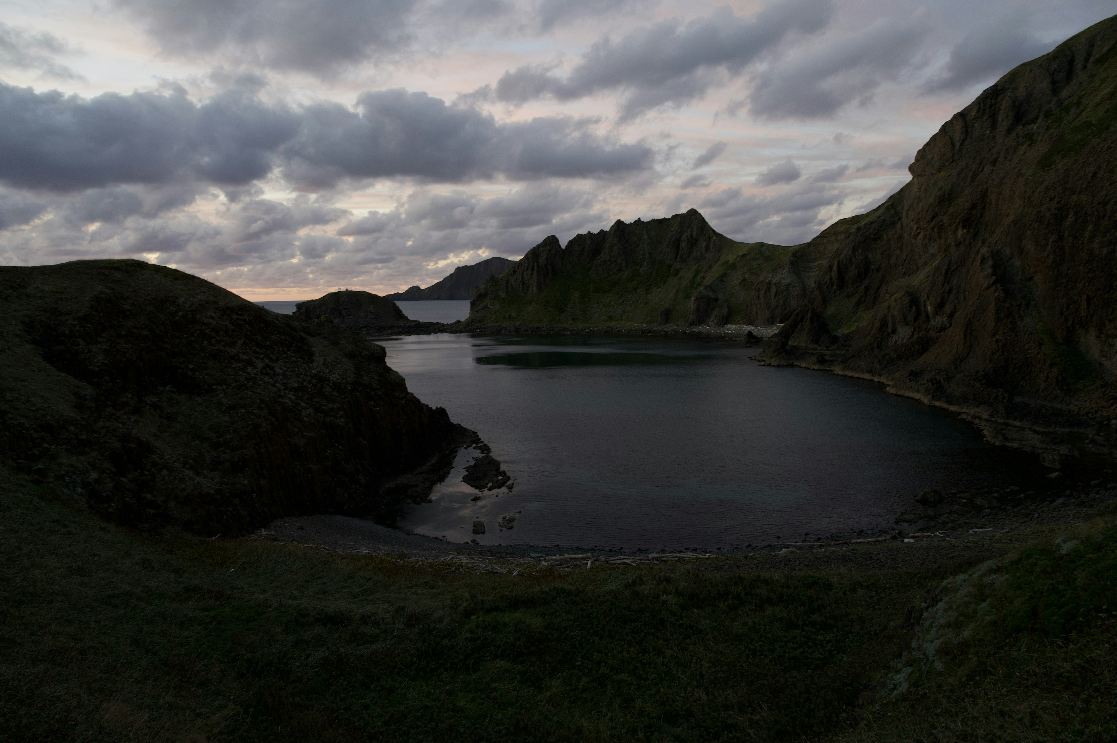 Serene cove with rugged mountains at dusk