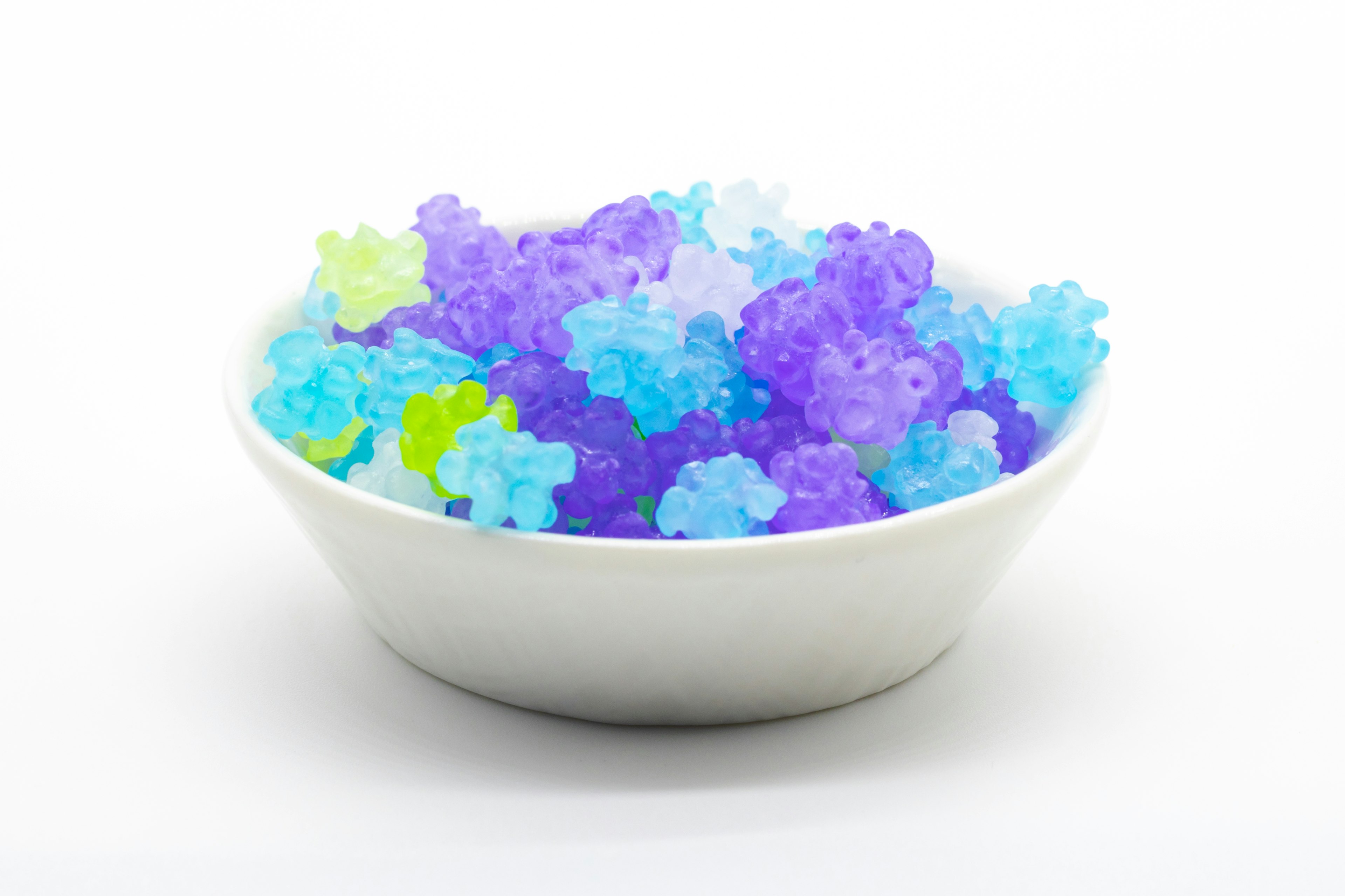 Colorful jelly-like flower-shaped sweets in a white bowl