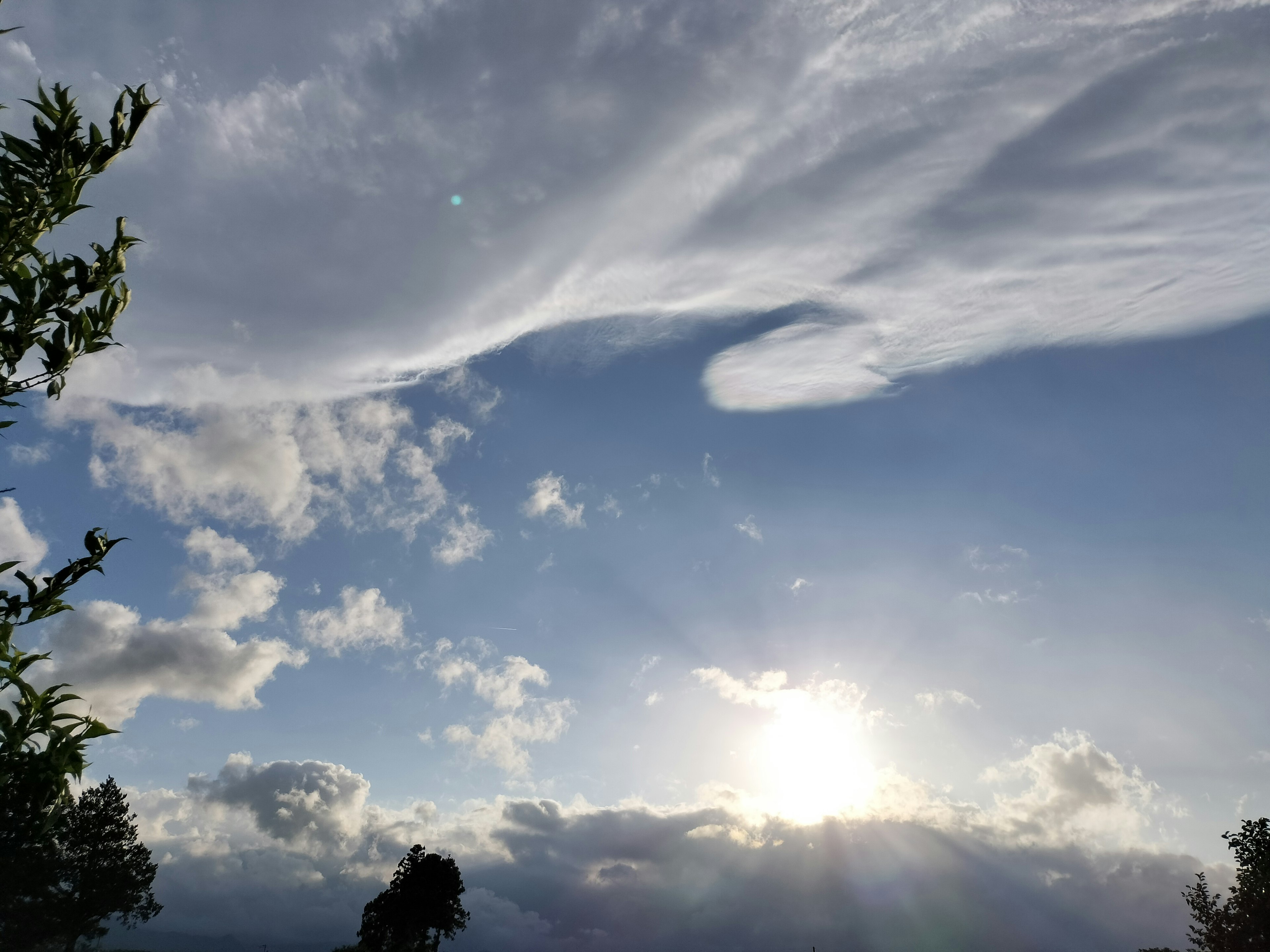 Una vista panoramica con nuvole bianche sotto un cielo blu e la luce del sole che splende