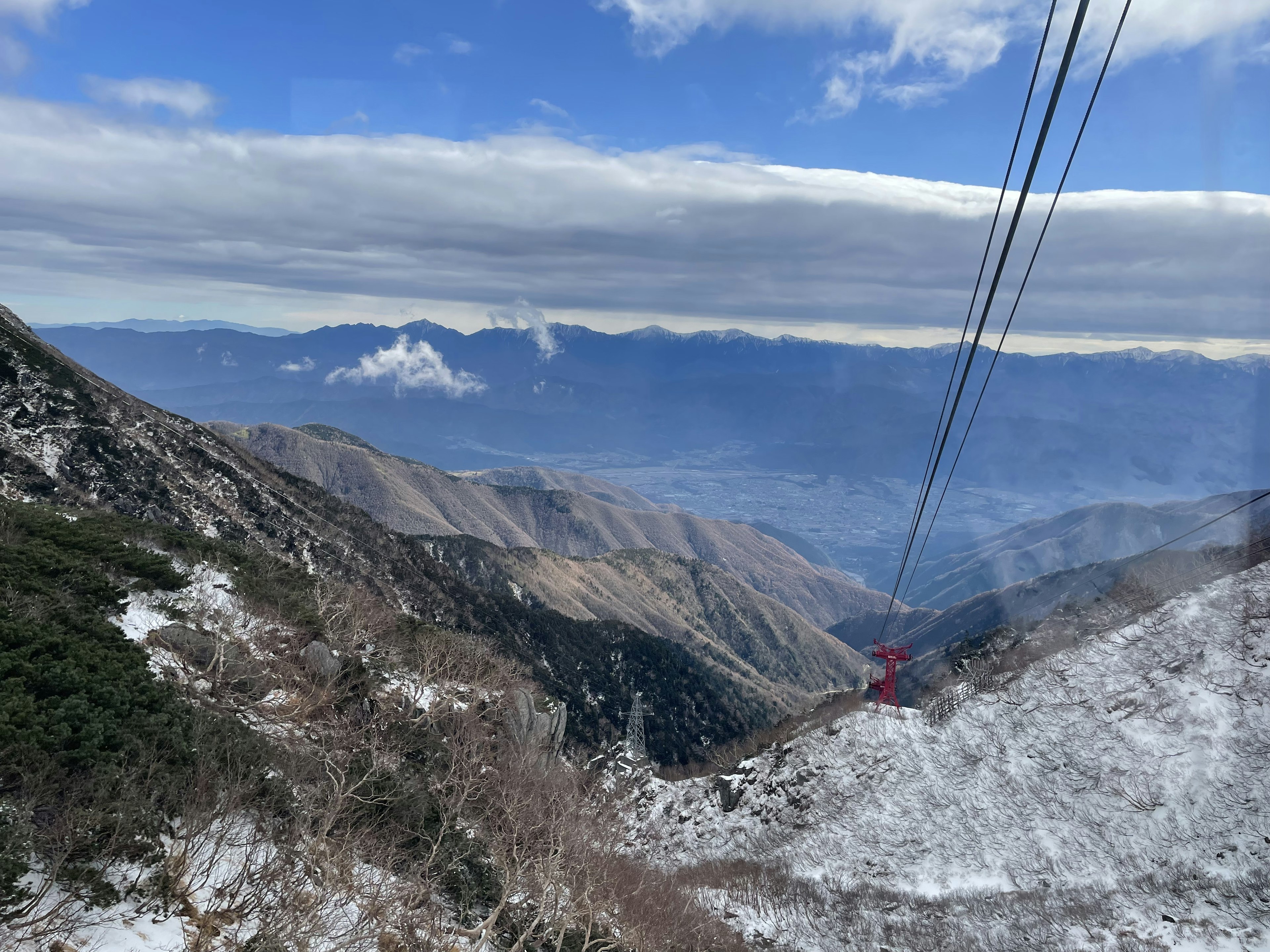 Panoramablick auf schneebedeckte Bergabhänge mit einer Seilbahn