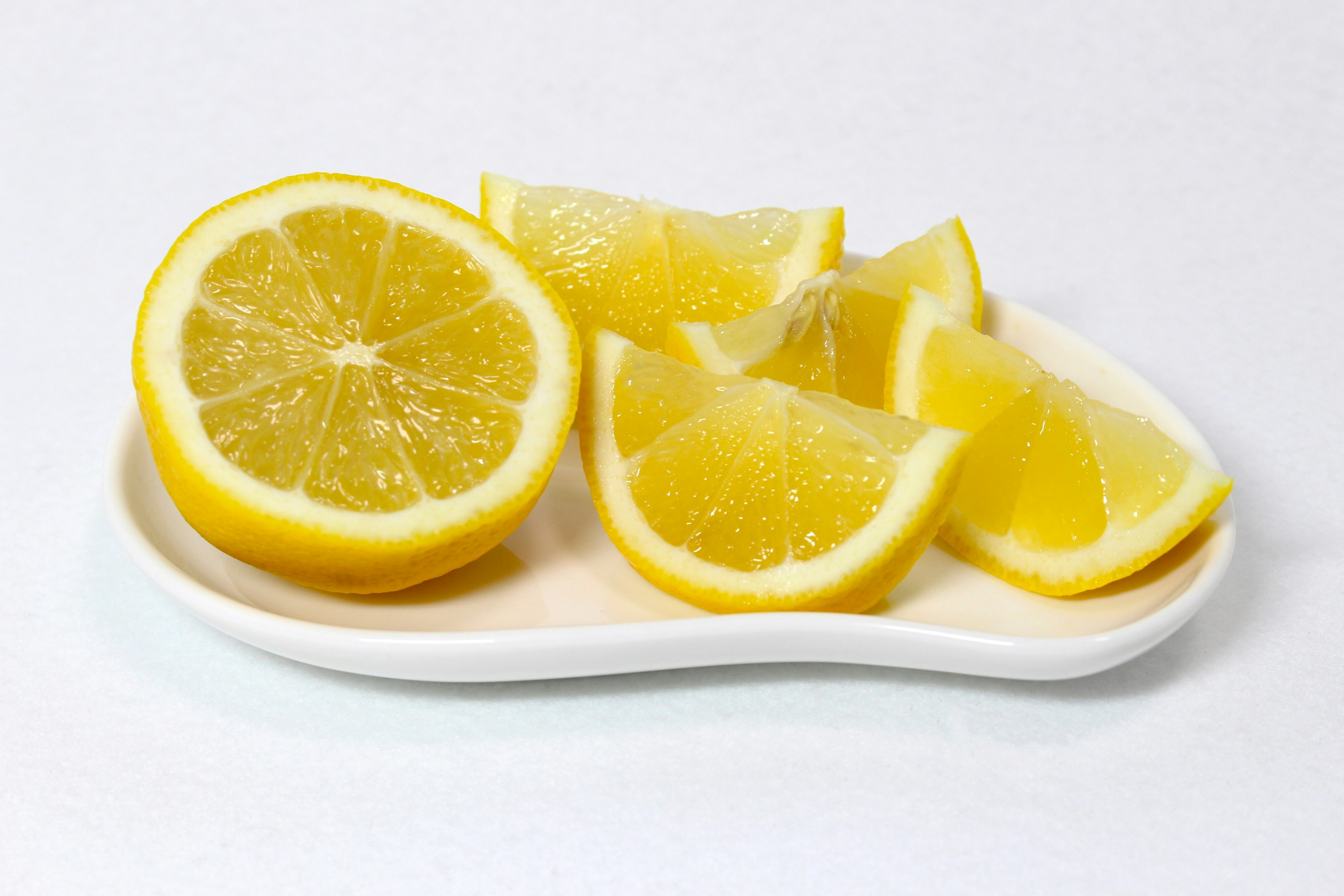 Fresh lemon slices and wedges arranged on a white dish