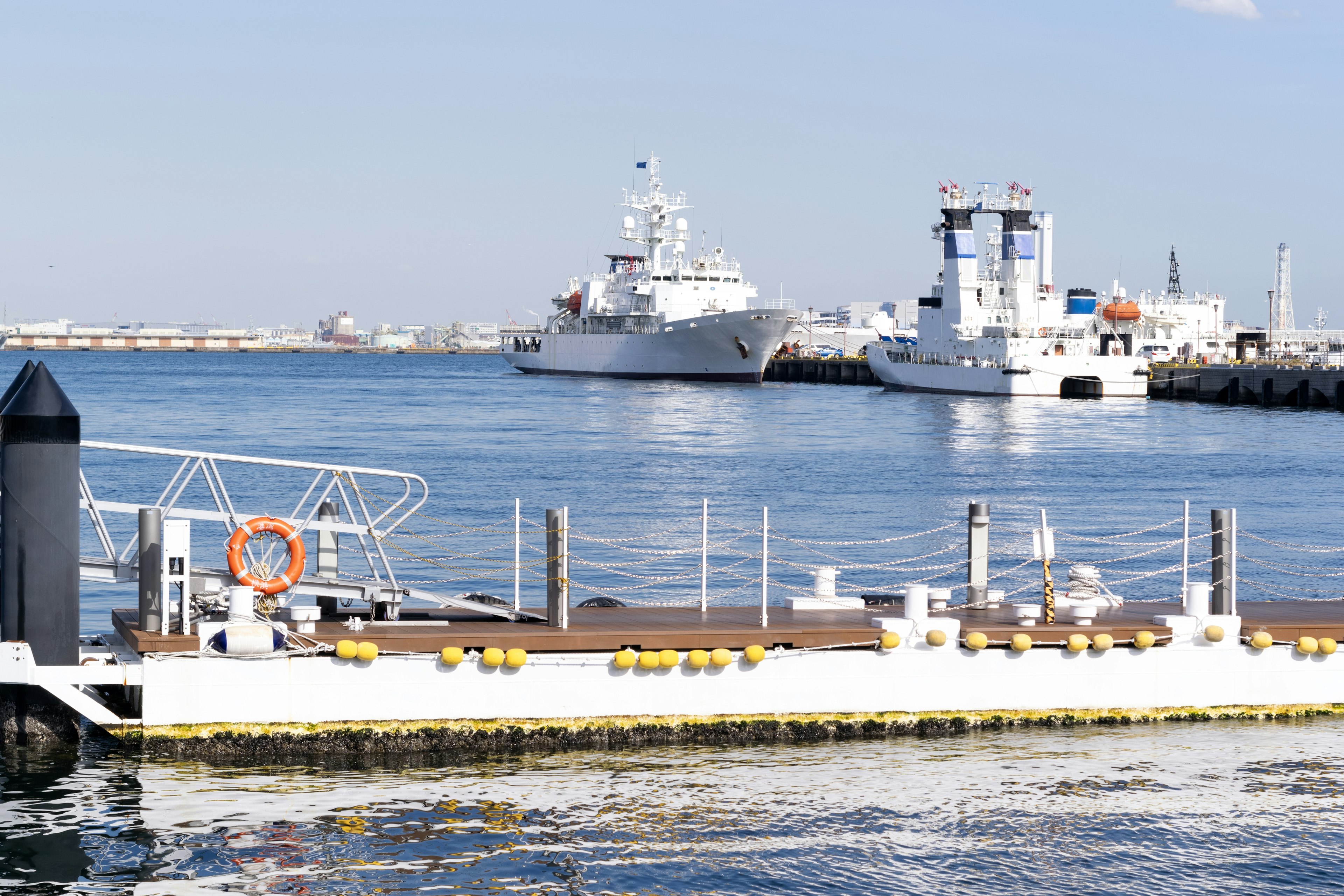 View of moored ships at a harbor under a clear blue sky