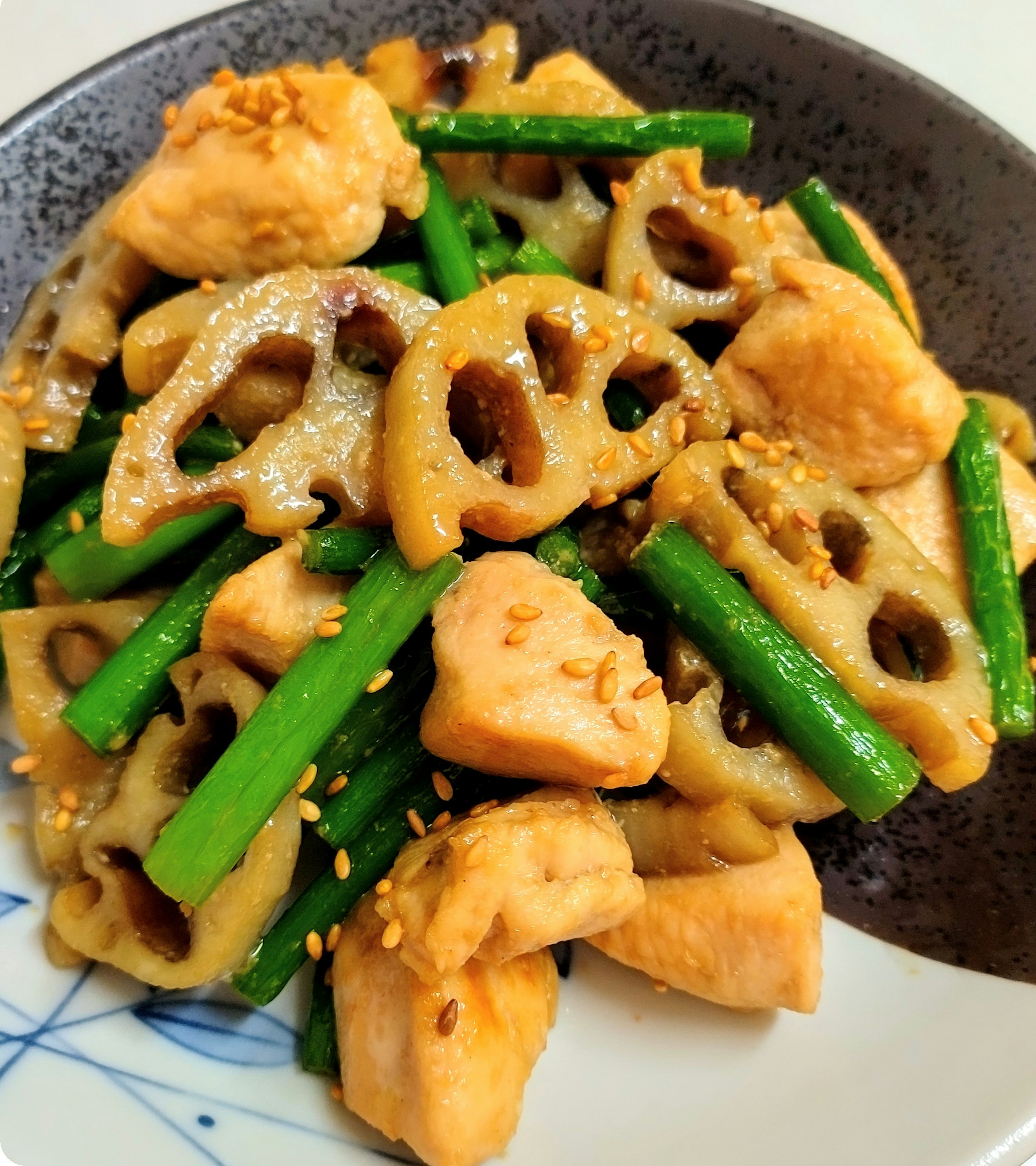 Poulet sauté avec racine de lotus et haricots verts dans une assiette