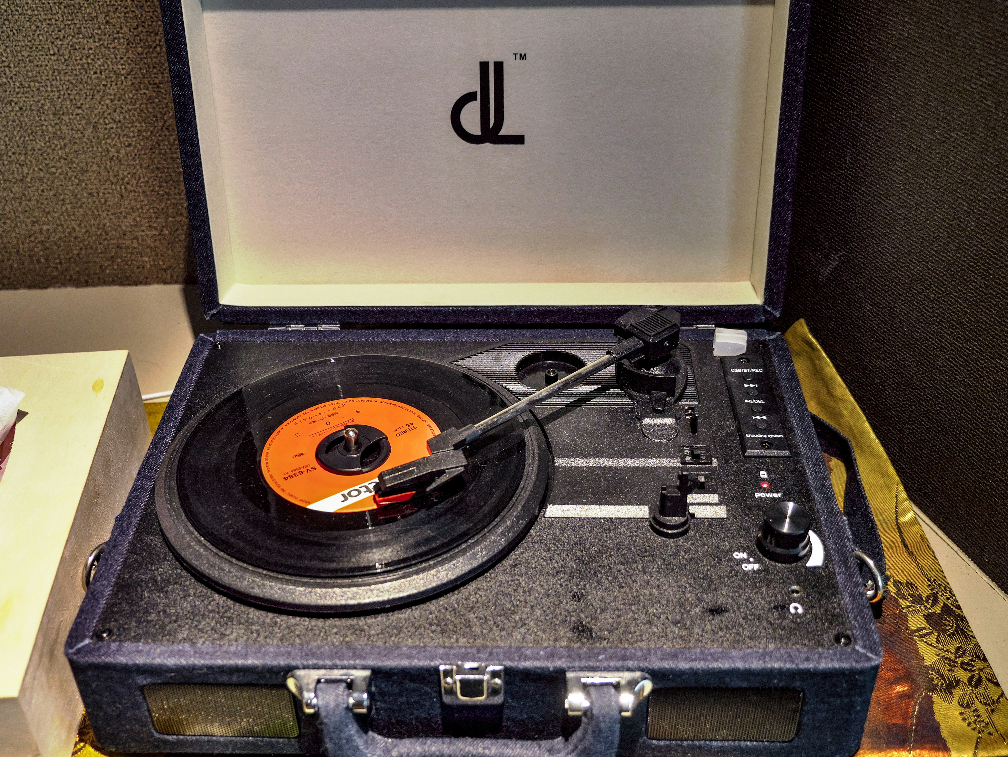 Retro record player in a black case with an orange vinyl