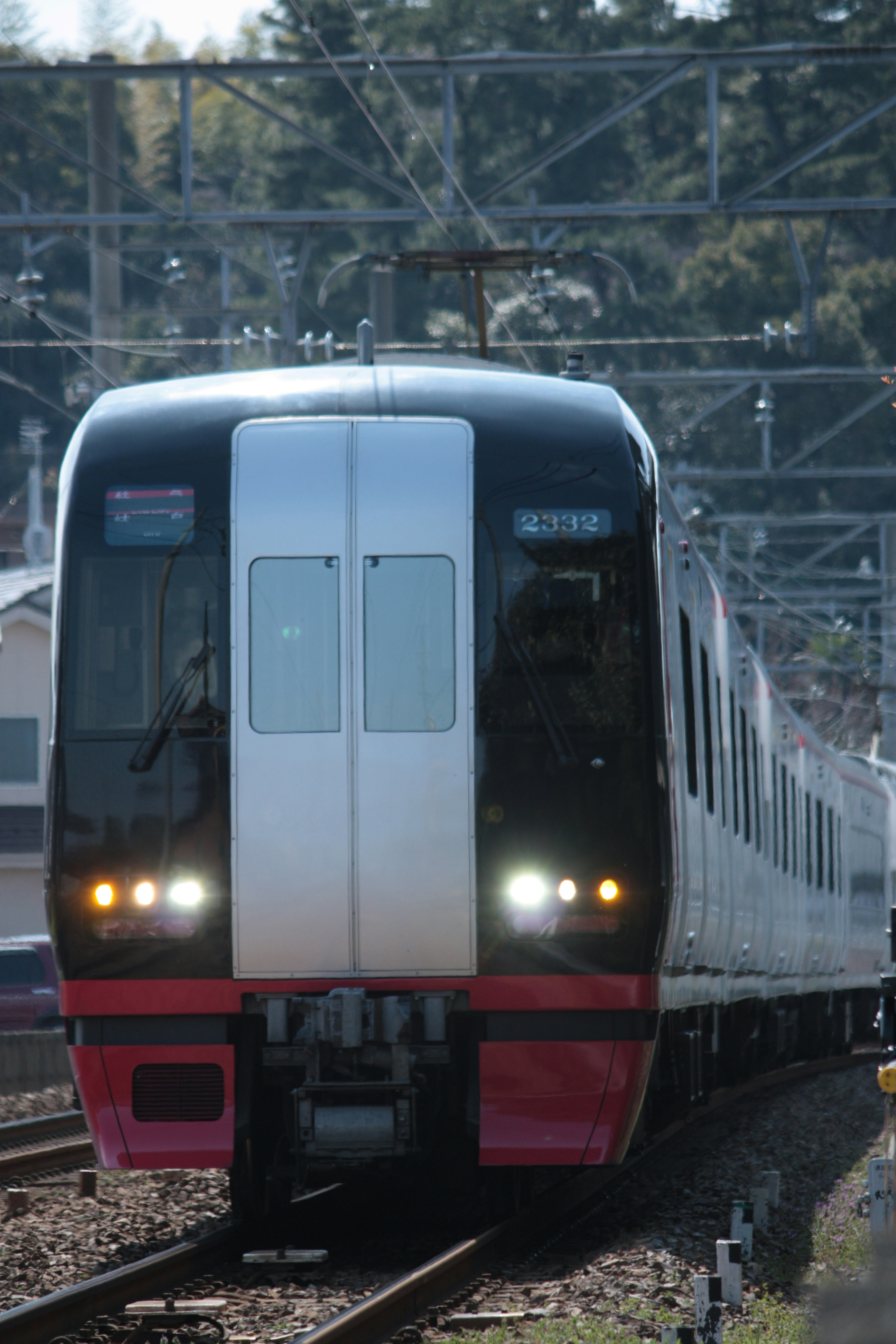 黒と白のデザインの電車が線路を走る