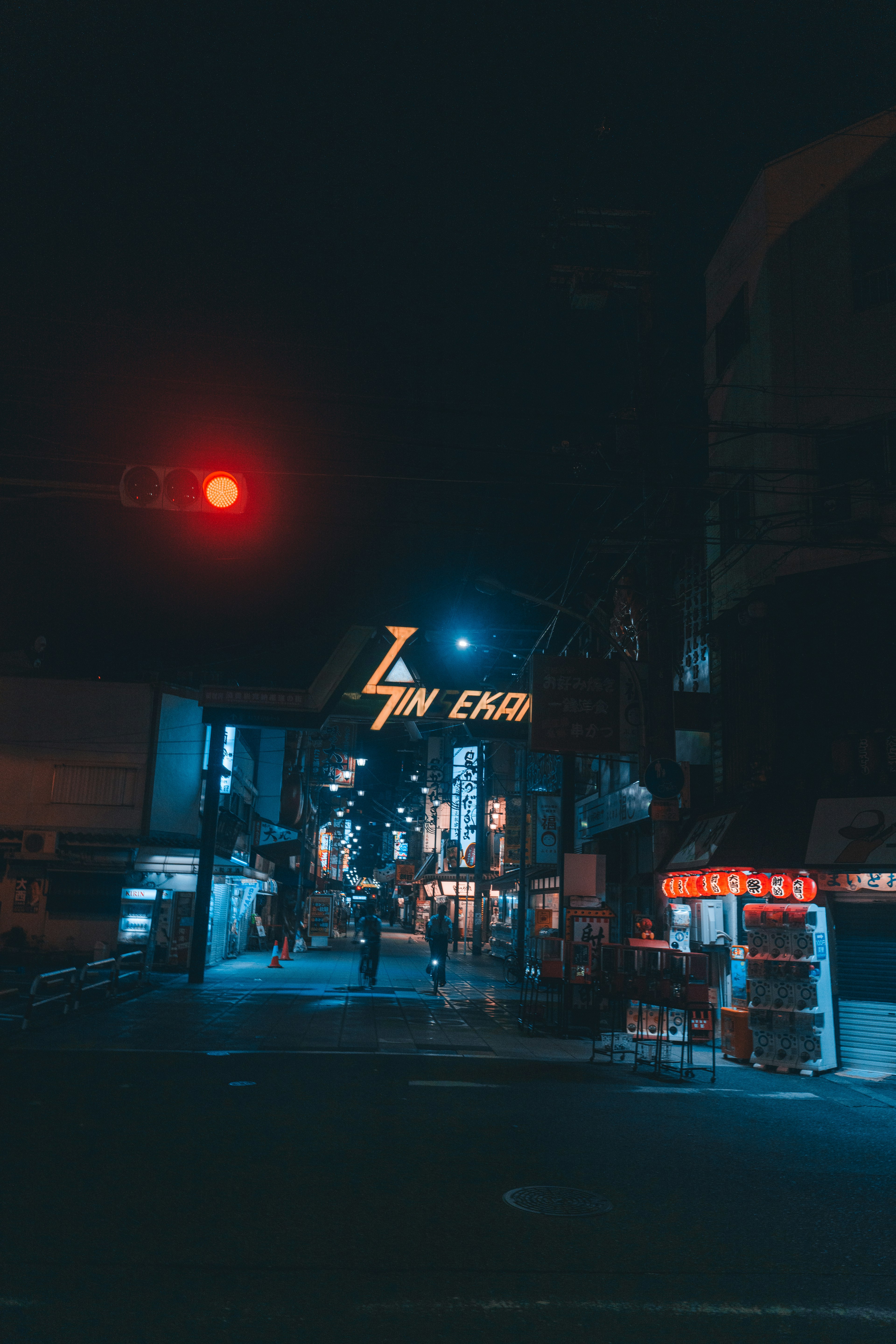 Night street scene with blue neon sign red traffic light