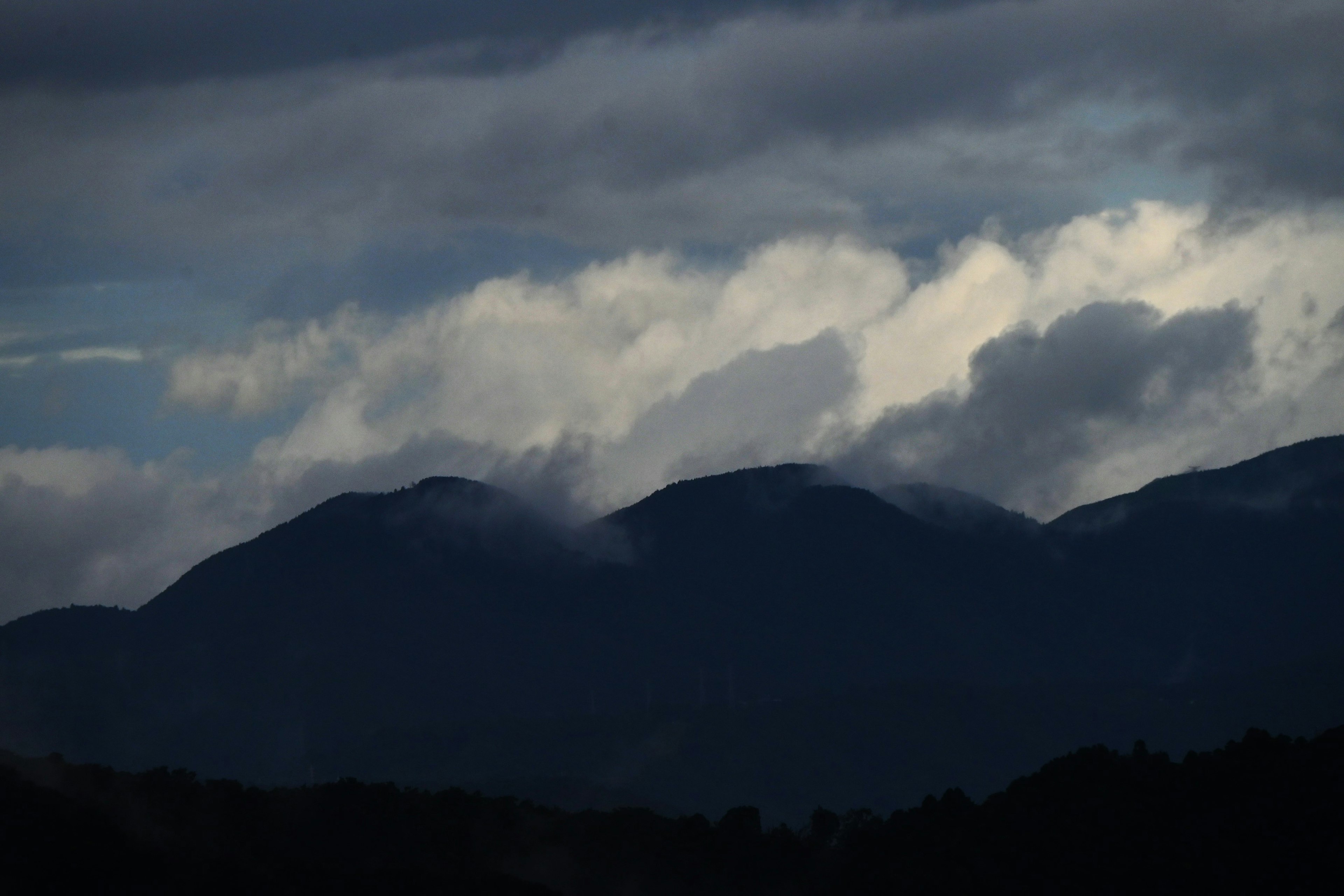 Siluet gunung yang diliputi awan gelap