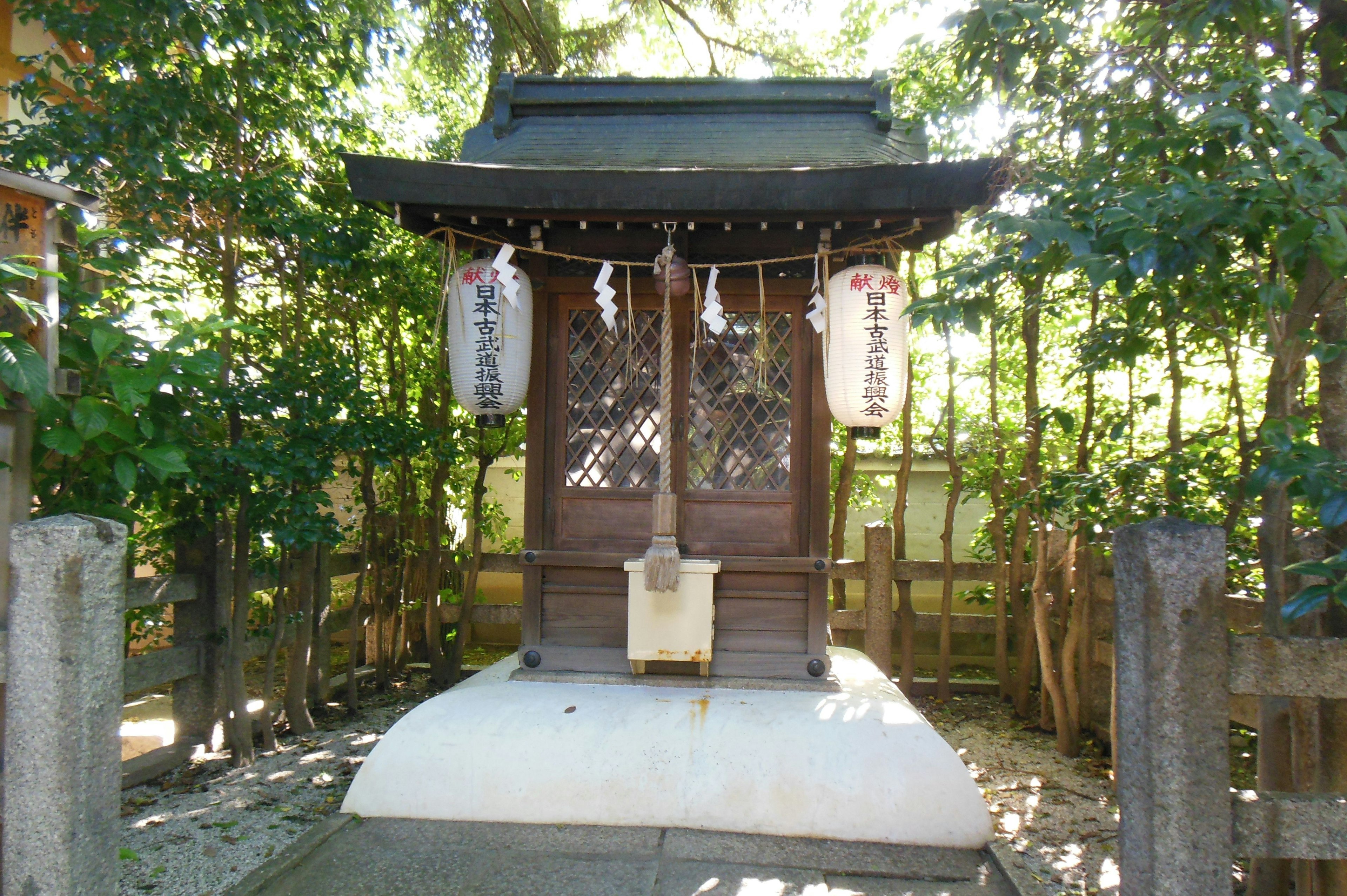 Wooden shrine building with lanterns in a serene setting