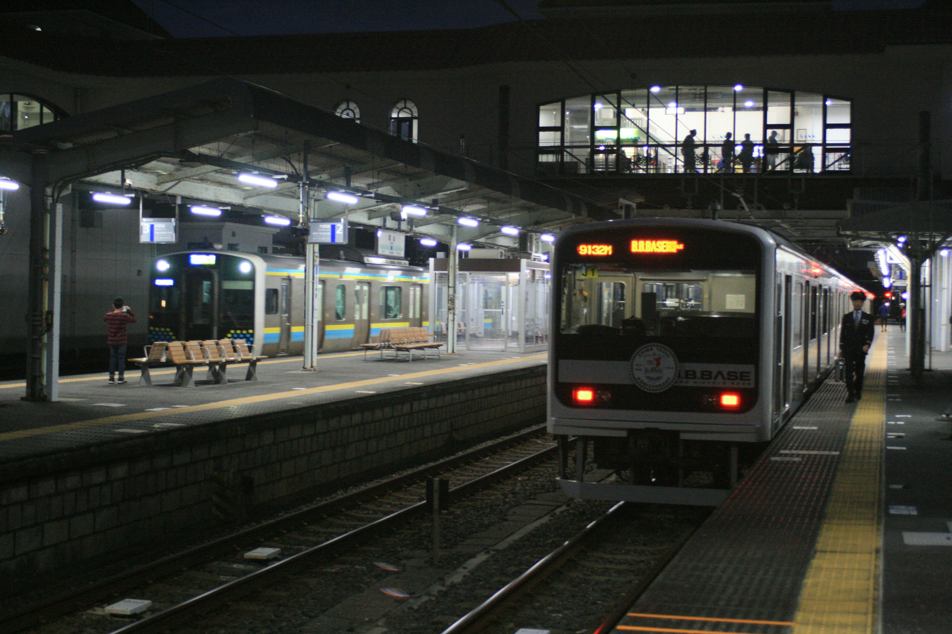 夜の駅で停車中の列車とホームのベンチ