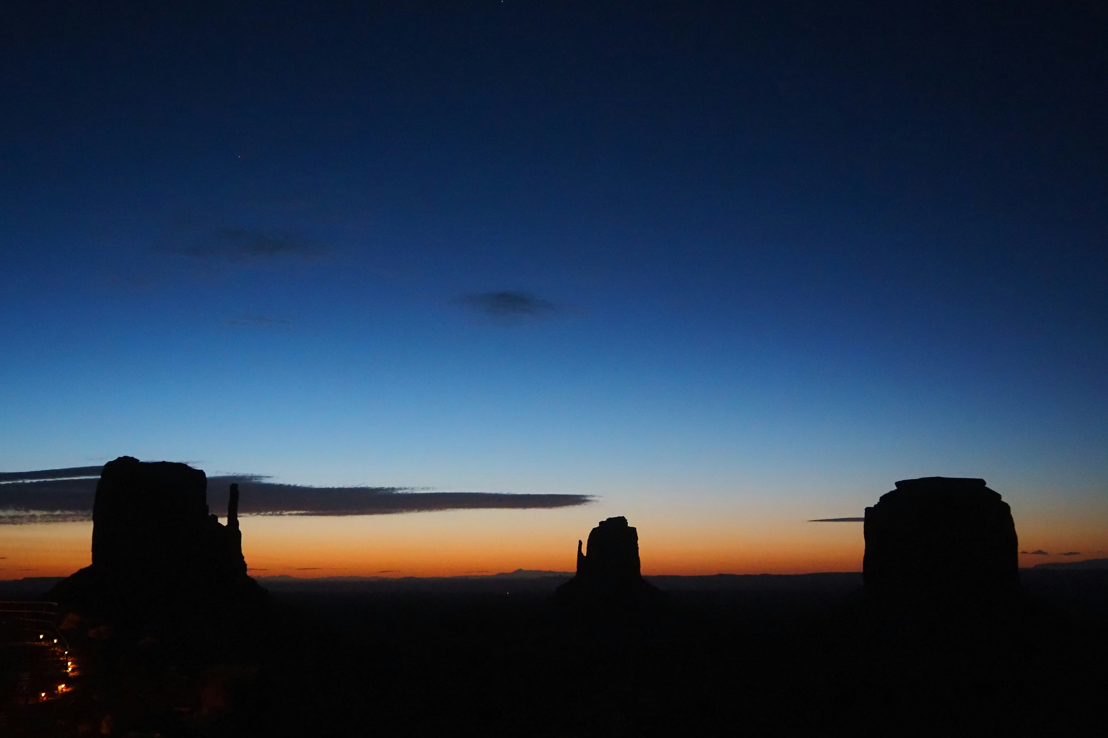 Siluet formasi batu Monument Valley melawan langit senja