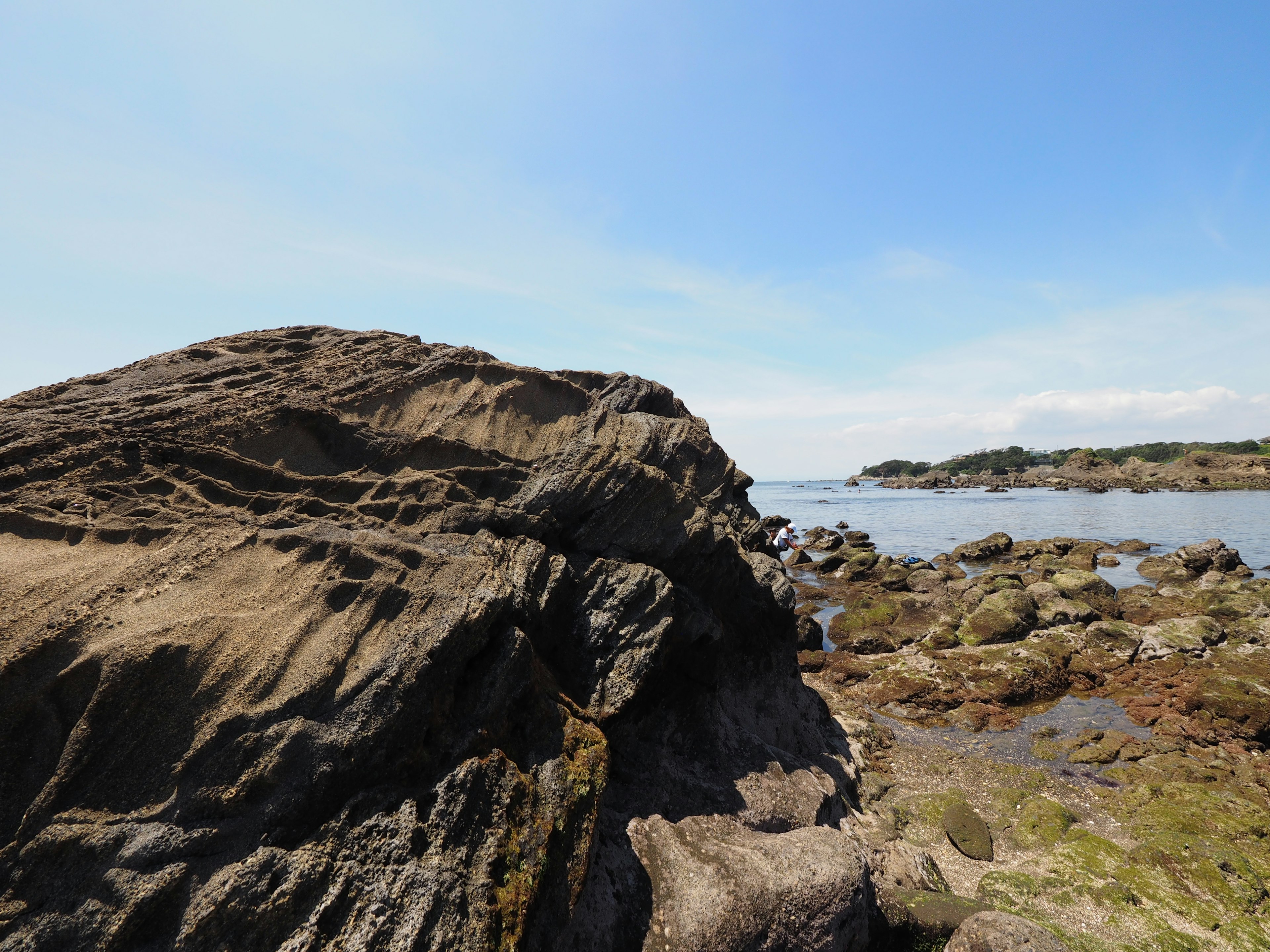 Batu besar di pantai dengan langit biru yang cerah