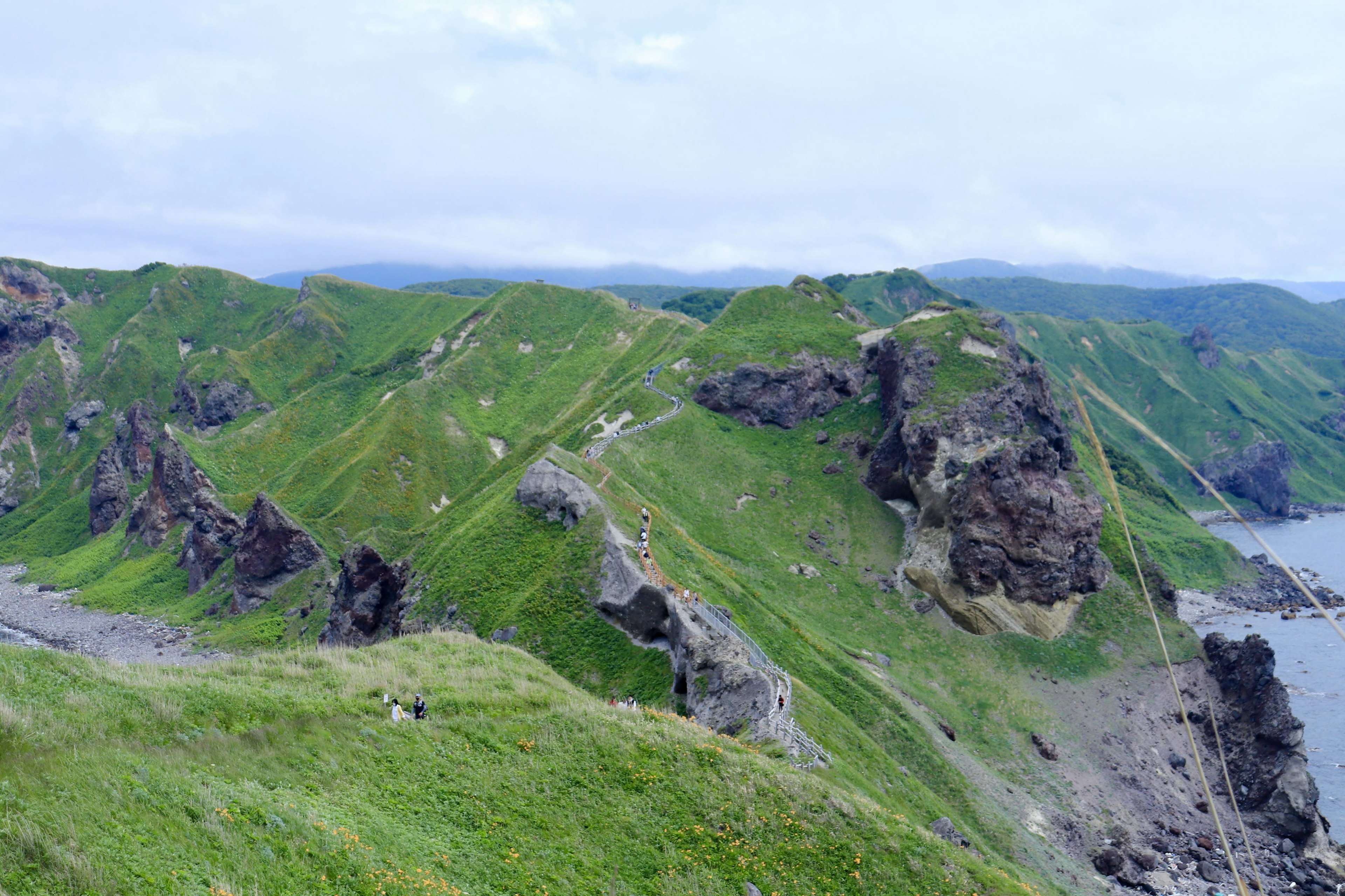 A landscape featuring green hills and rocky coastline