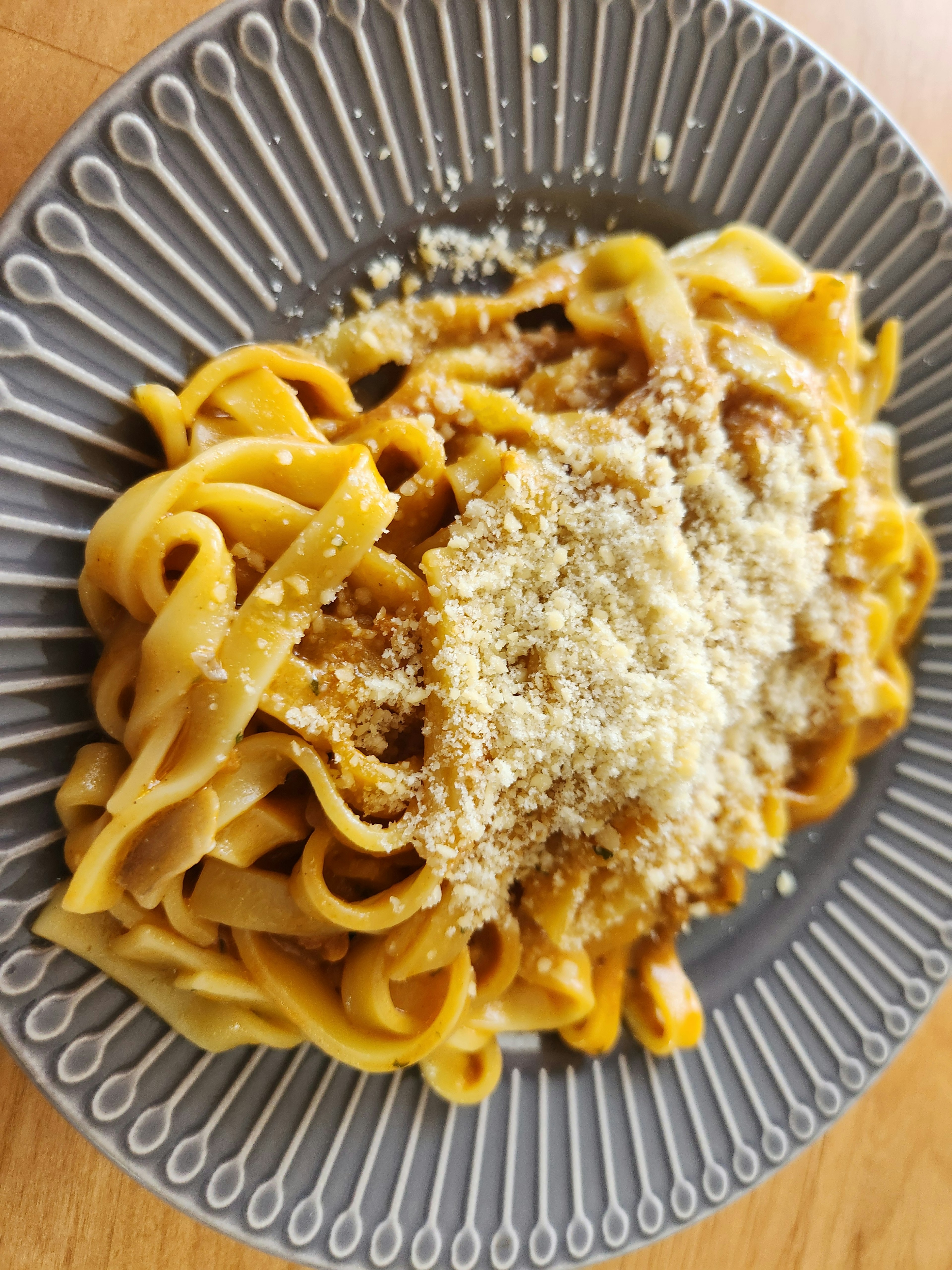 Plate of fettuccine pasta topped with grated Parmesan cheese