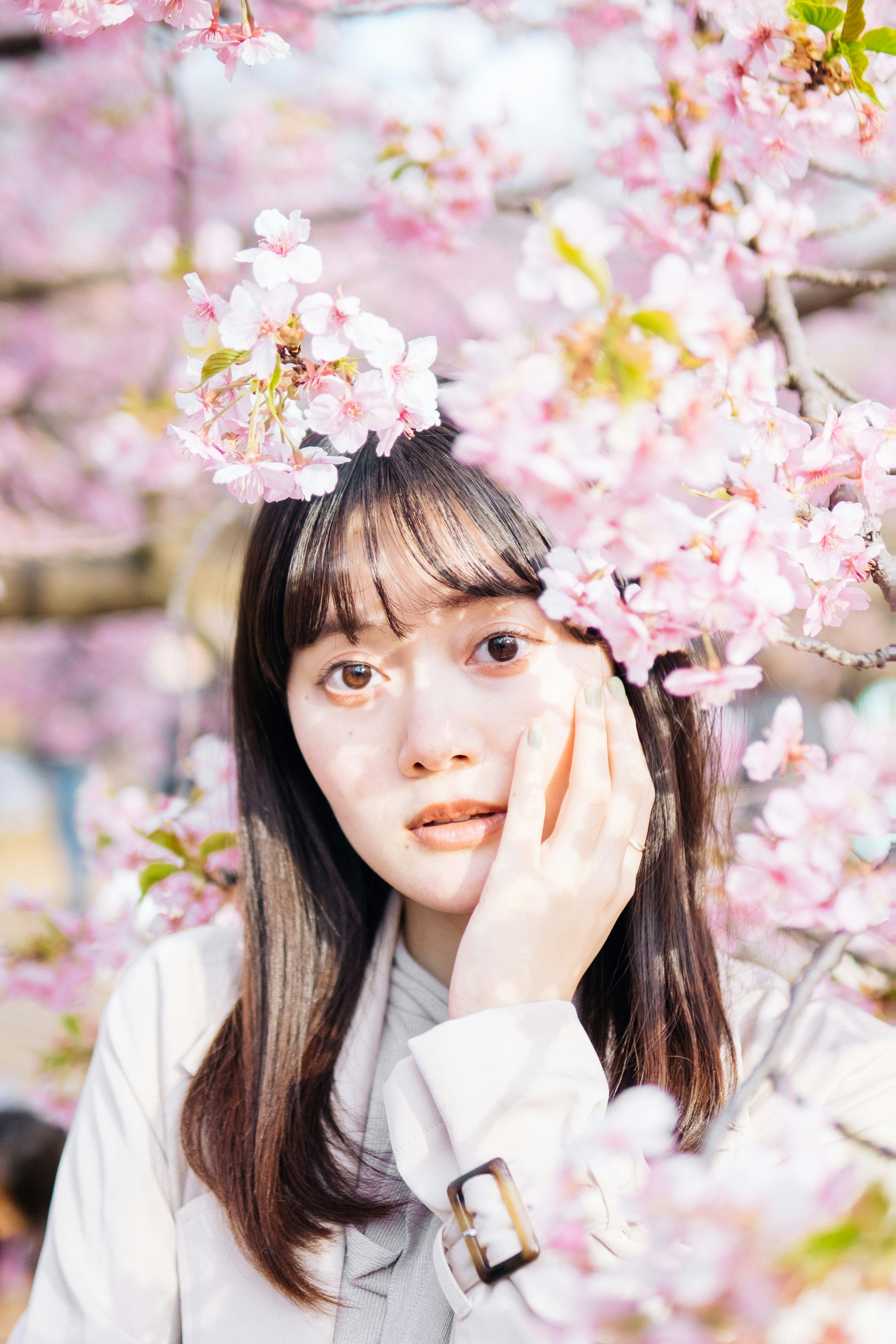 桜の花の間にいる女性のポートレート