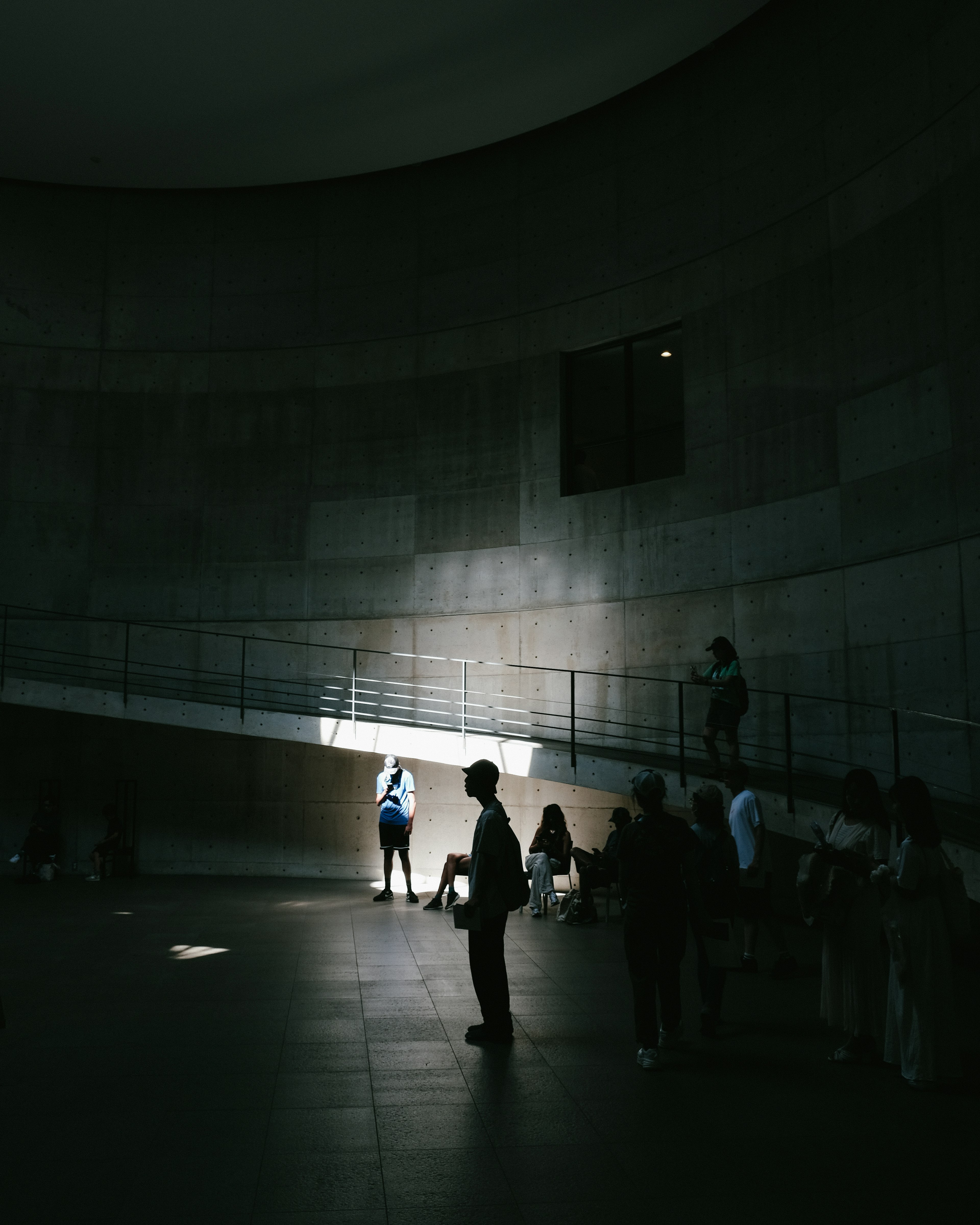 People standing in a modern building interior with bright light streaming in