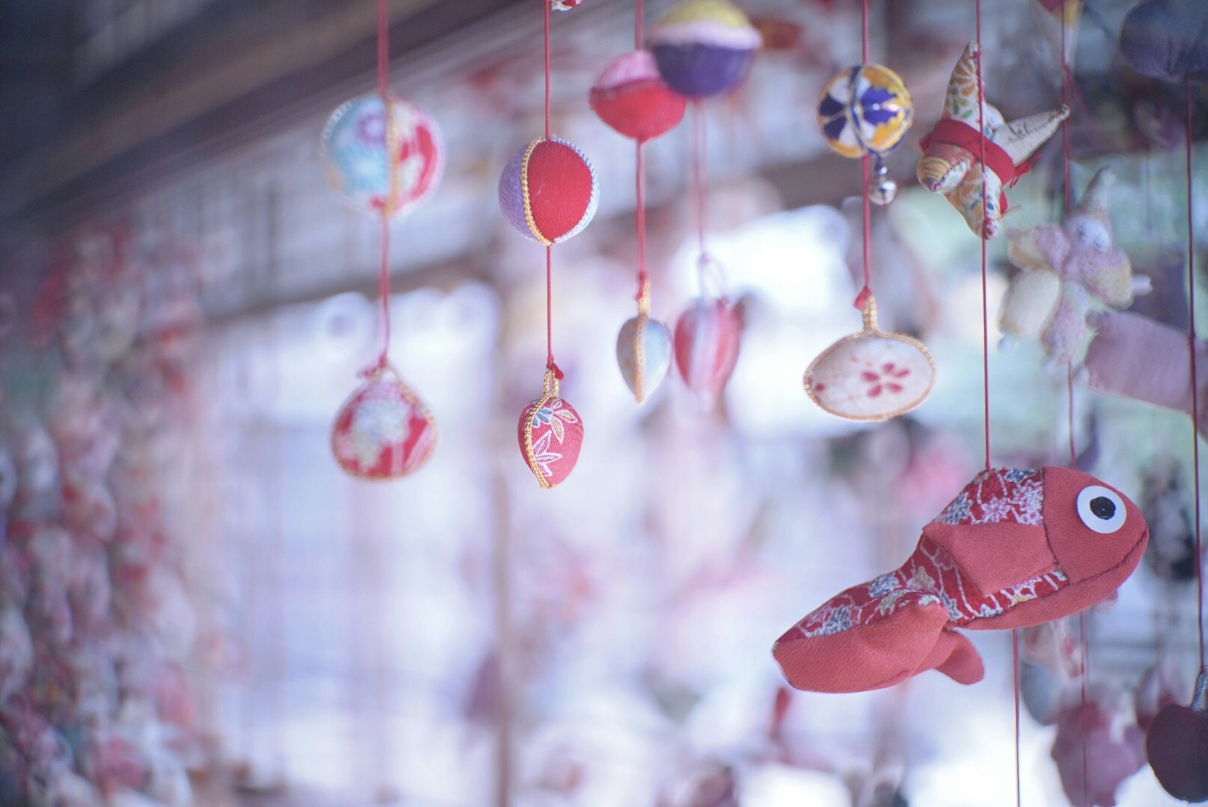 Imagen con decoraciones de peces rojos y adornos colgantes coloridos en luz suave