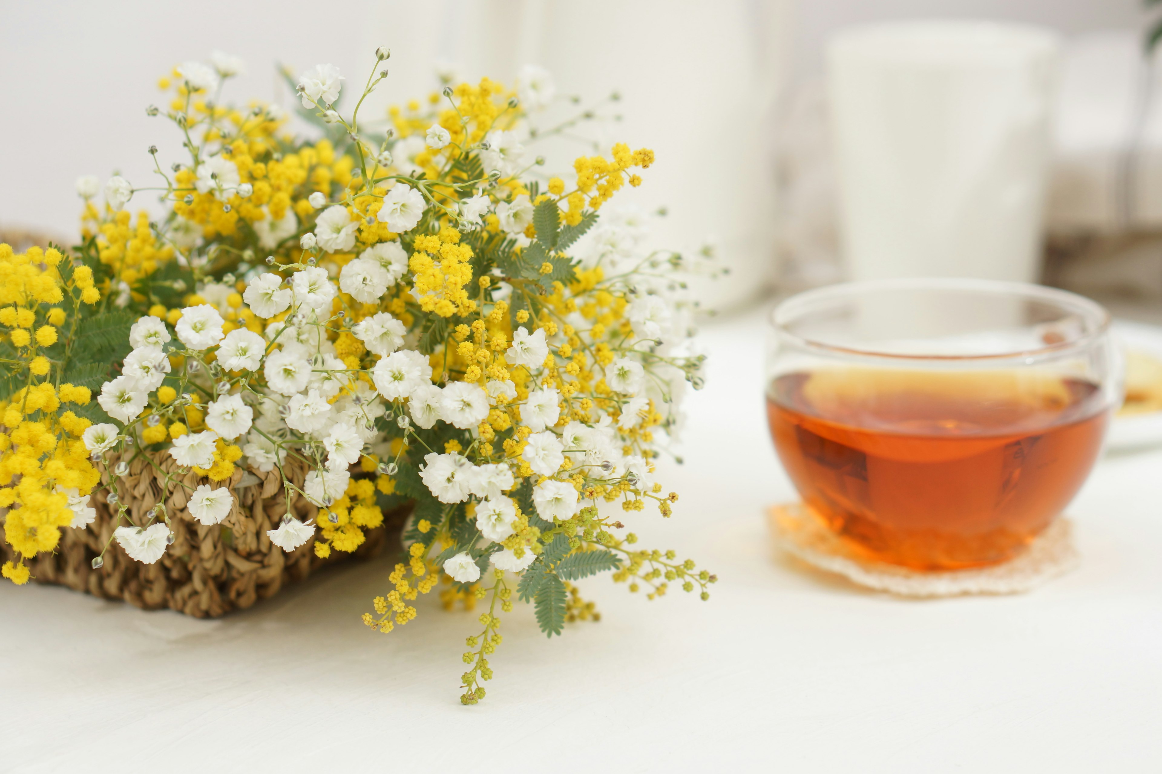 Un bouquet de fleurs jaunes et blanches avec une tasse de thé