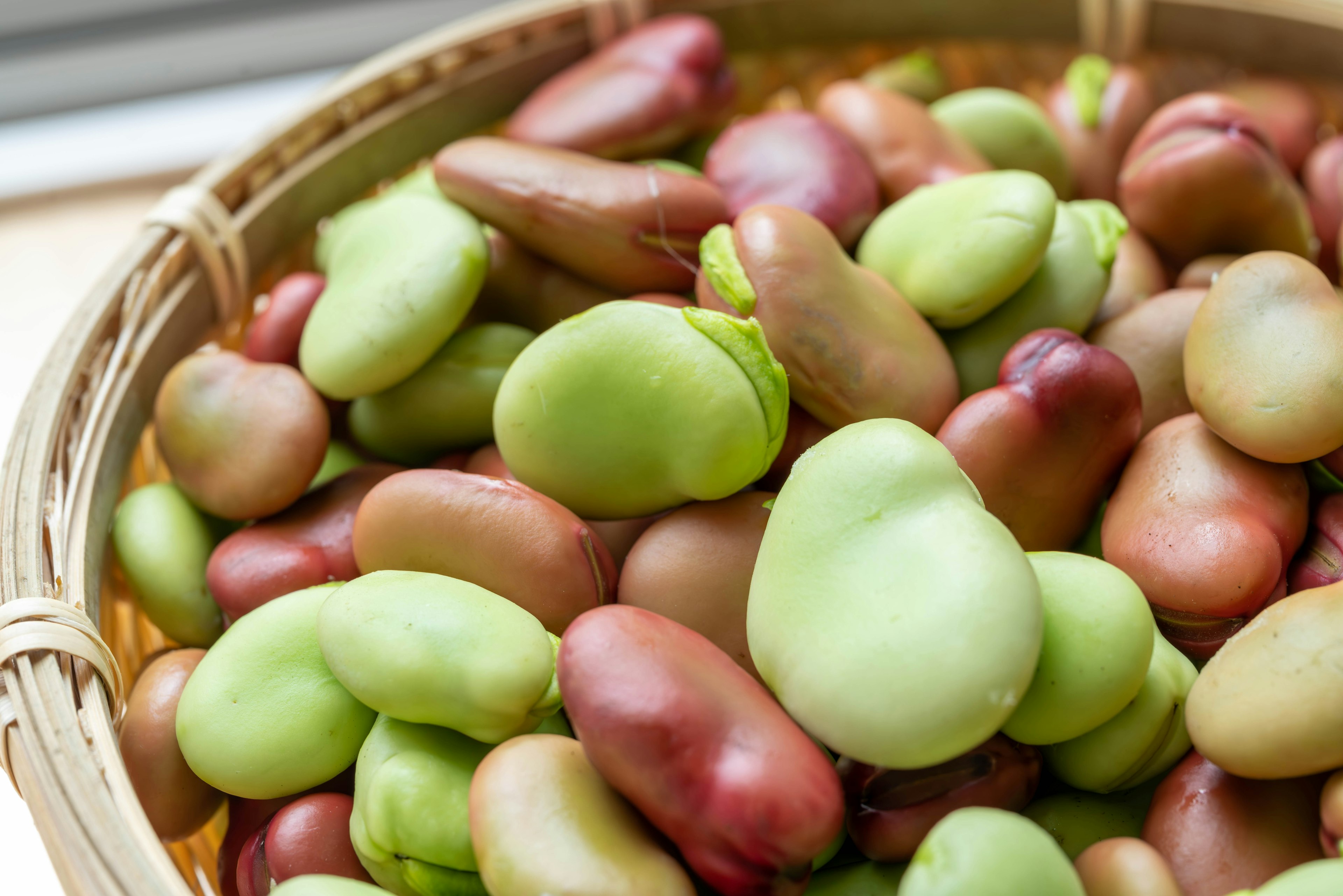 Close-up of various colored beans in a woven basket