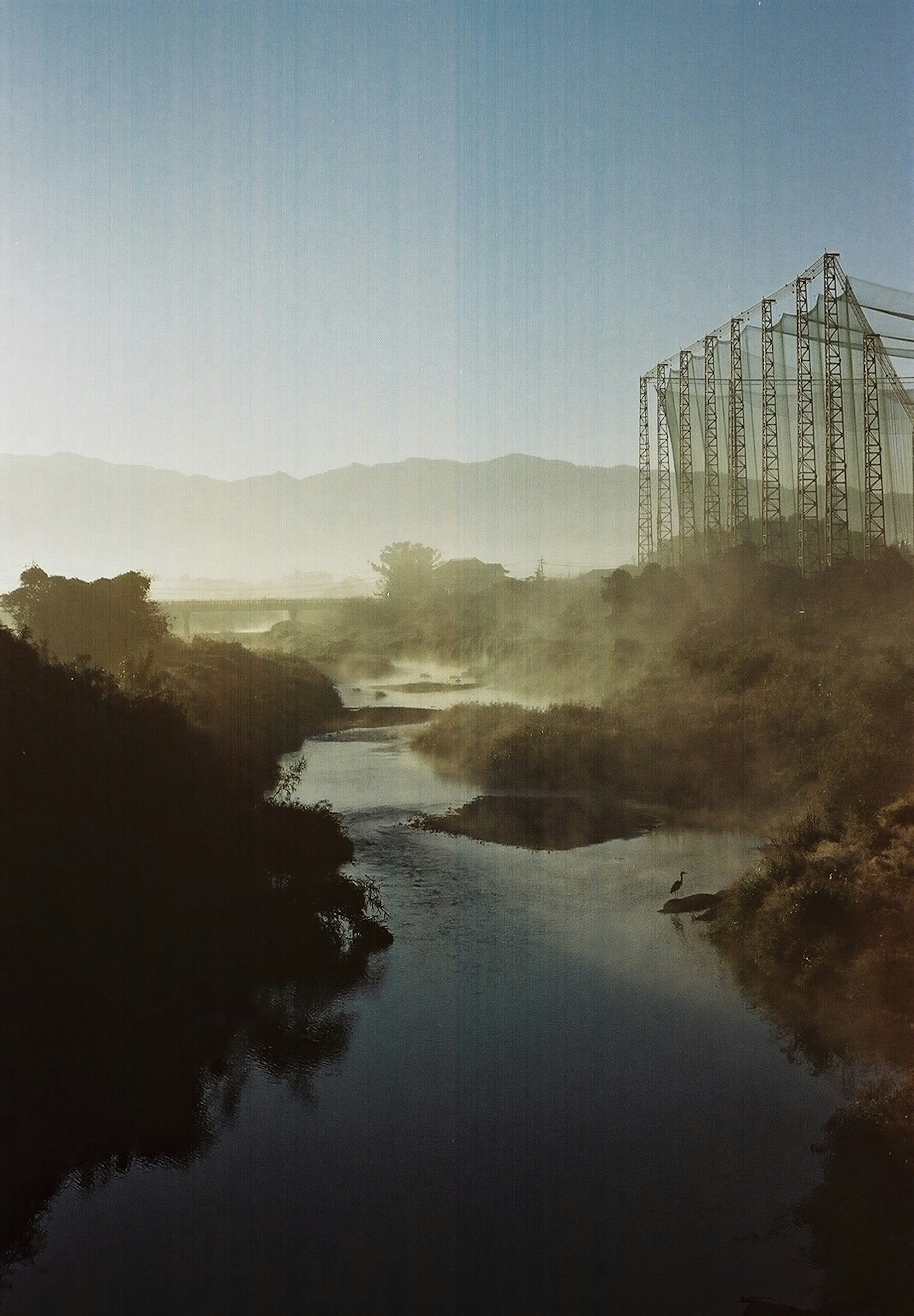 Misty river landscape with mountains in the background