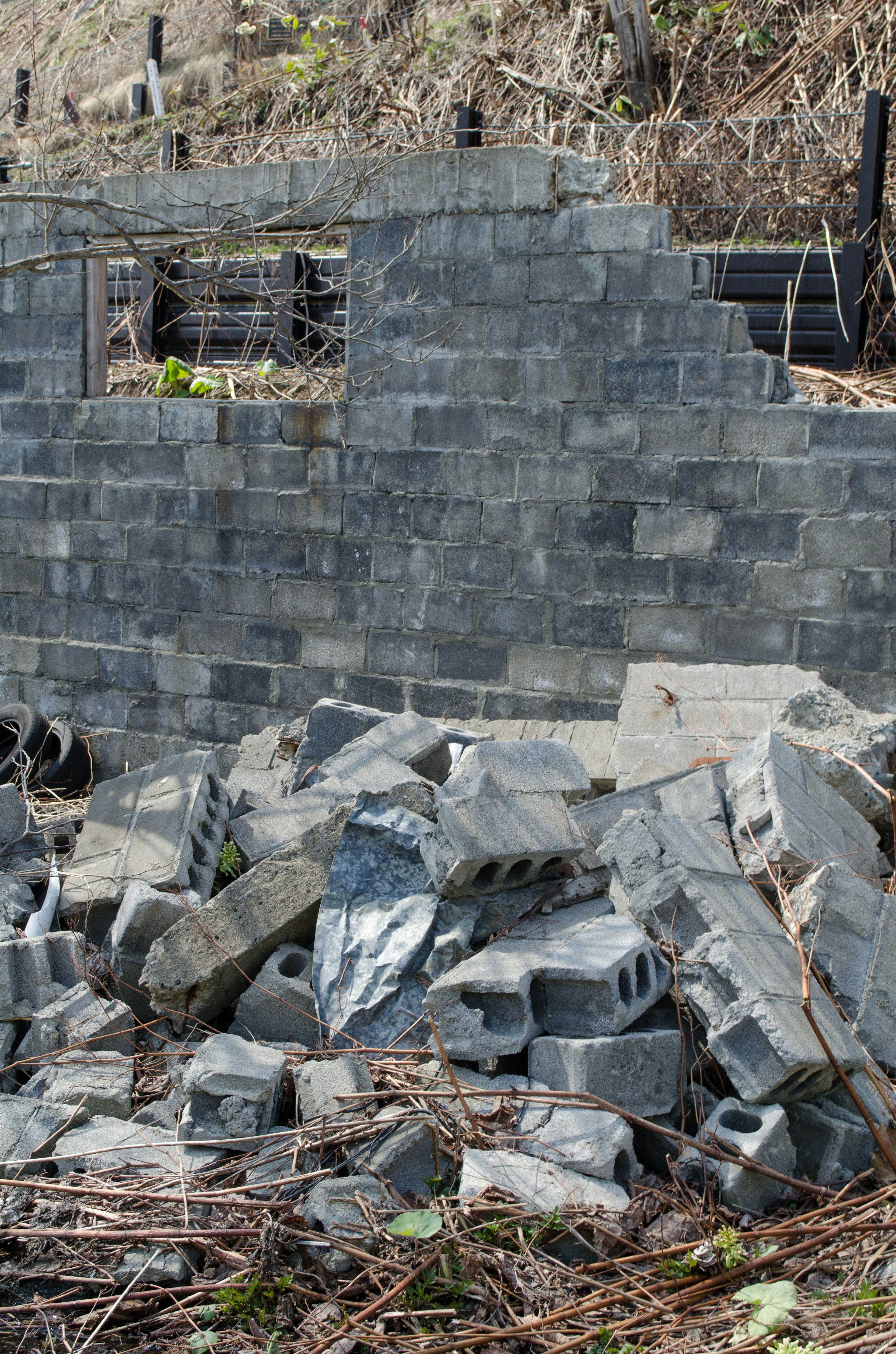 Mur en blocs de béton effondré avec des blocs éparpillés autour