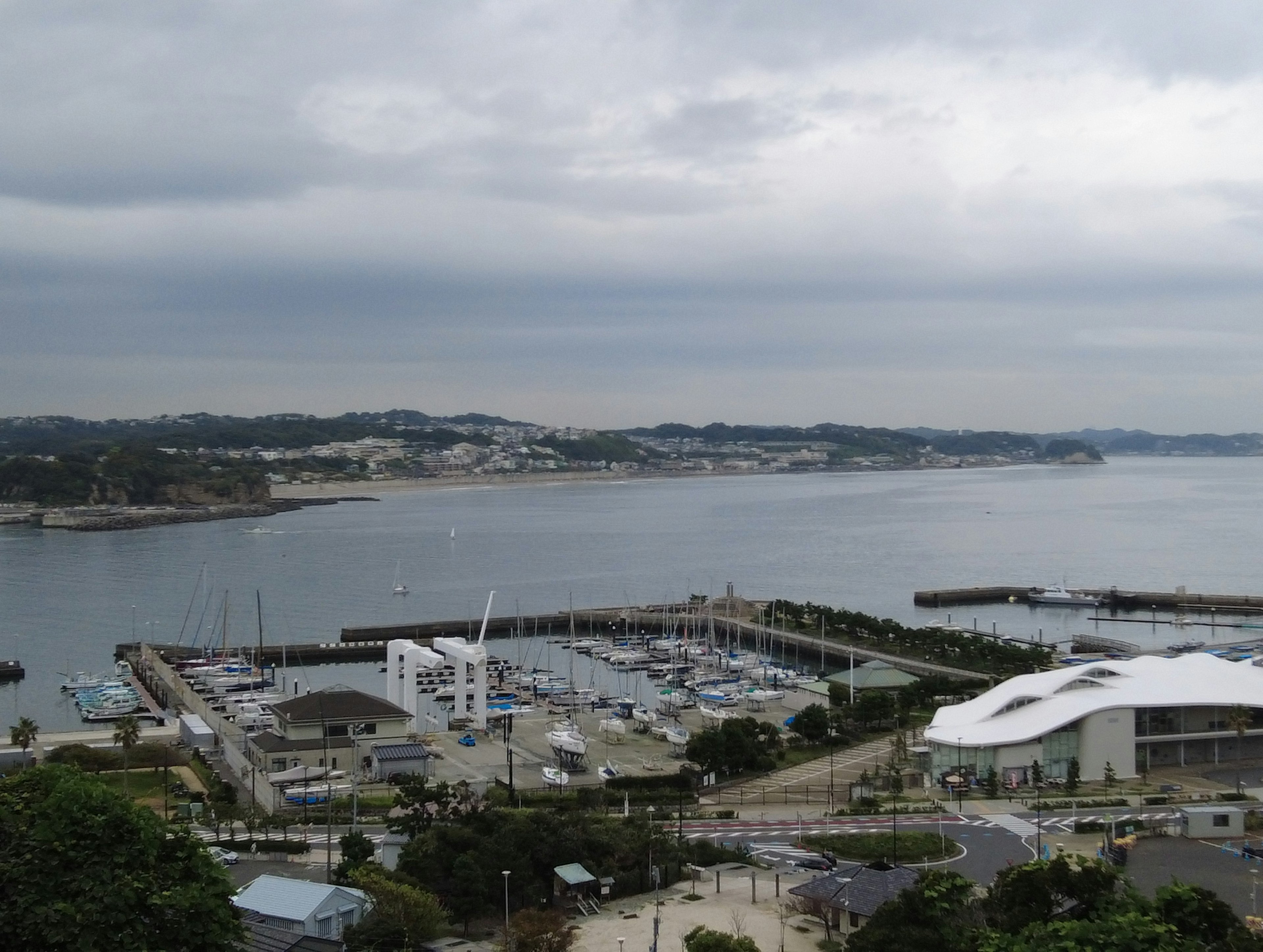 Vista panoramica di un porto e del mare con cielo nuvoloso e barche ormeggiate