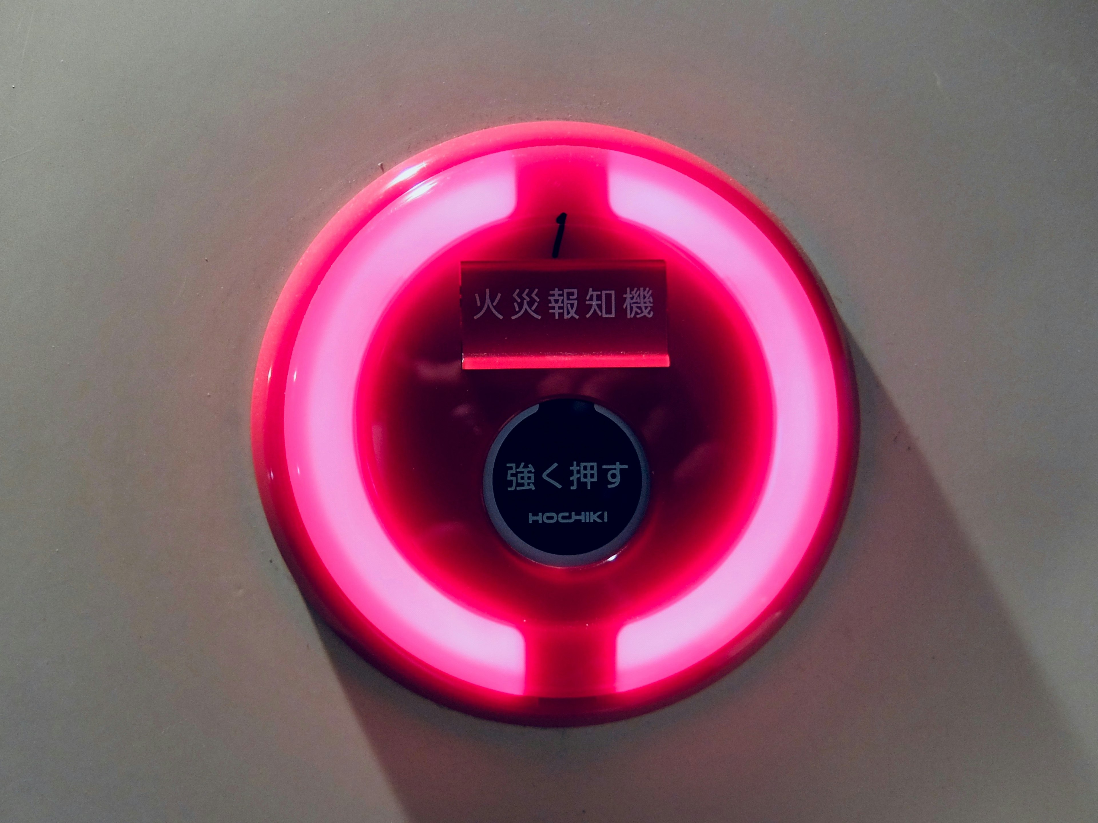 Wall-mounted fire alarm with a bright red light