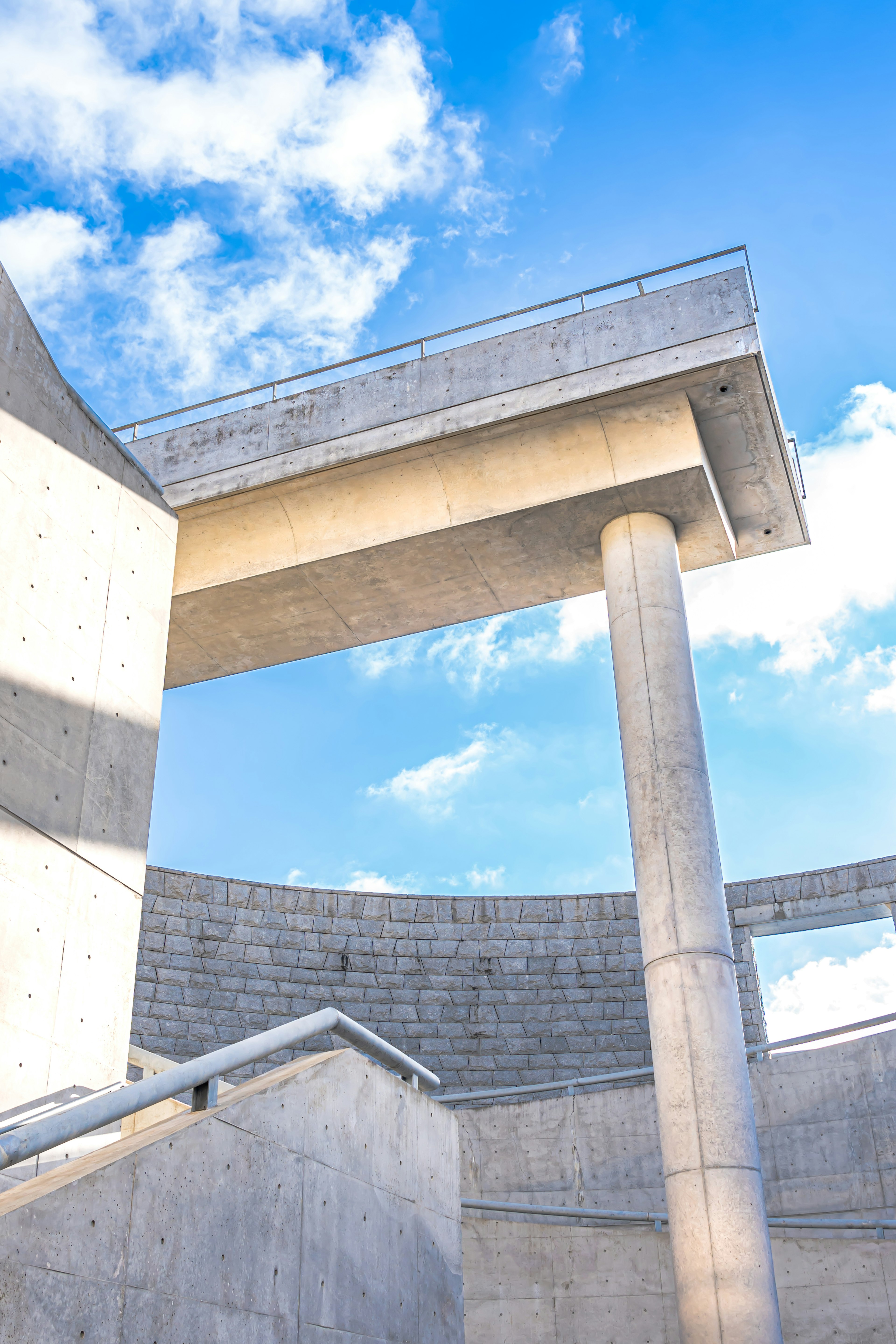 Estructura arquitectónica de concreto con un pilar bajo un cielo azul