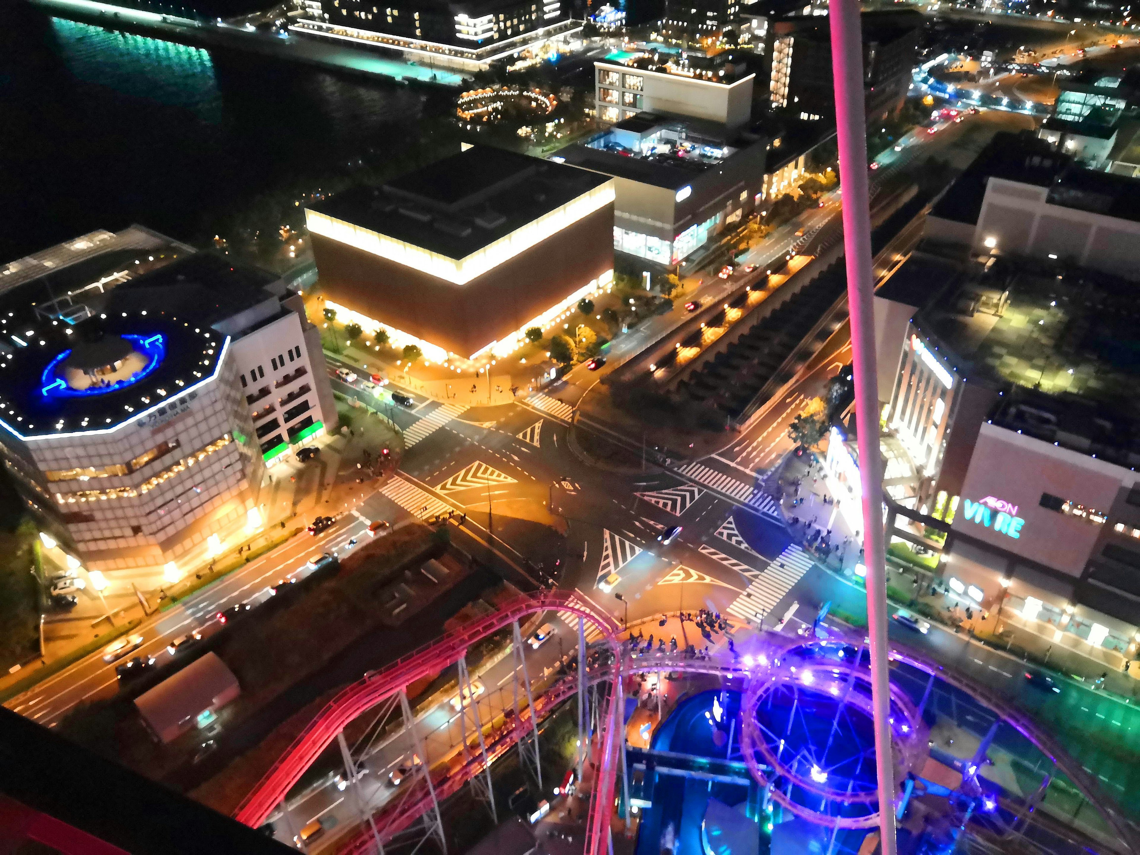 Night cityscape with illuminated buildings vibrant street lights amusement park rides