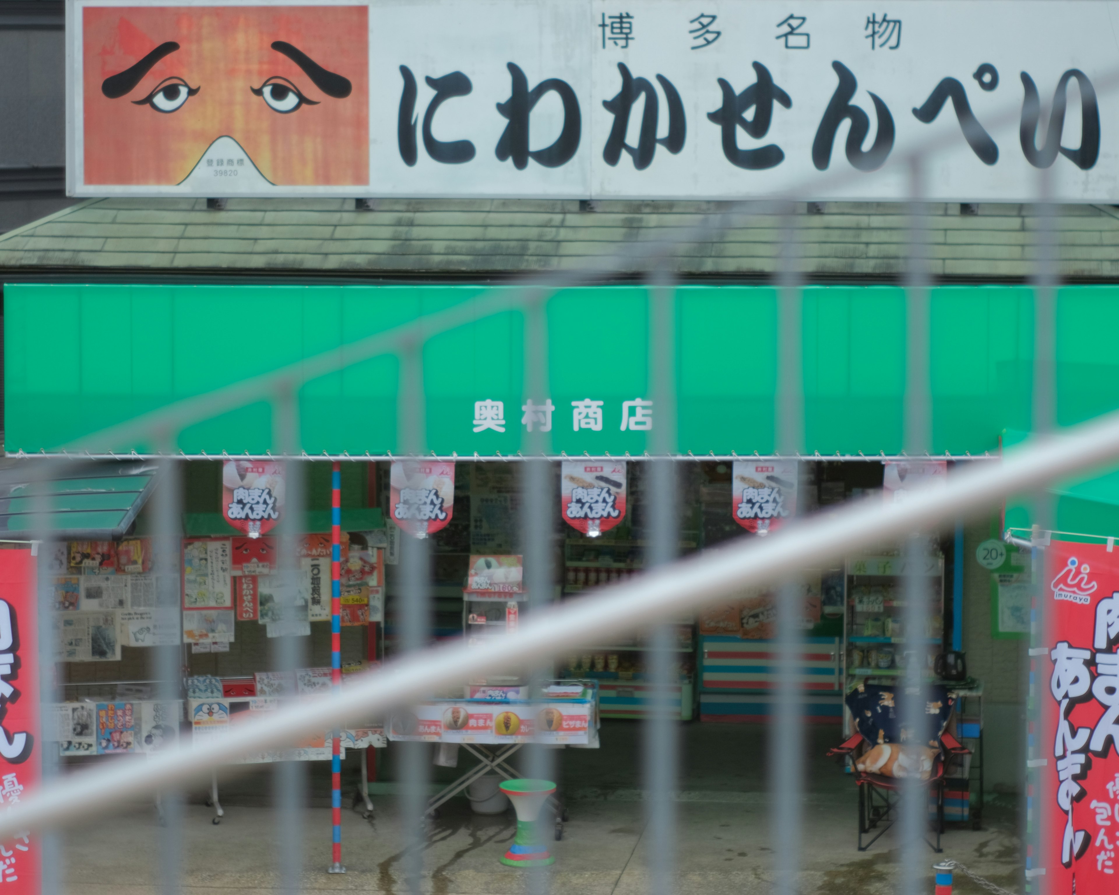 Vitrine avec un toit vert et un grand panneau de visage