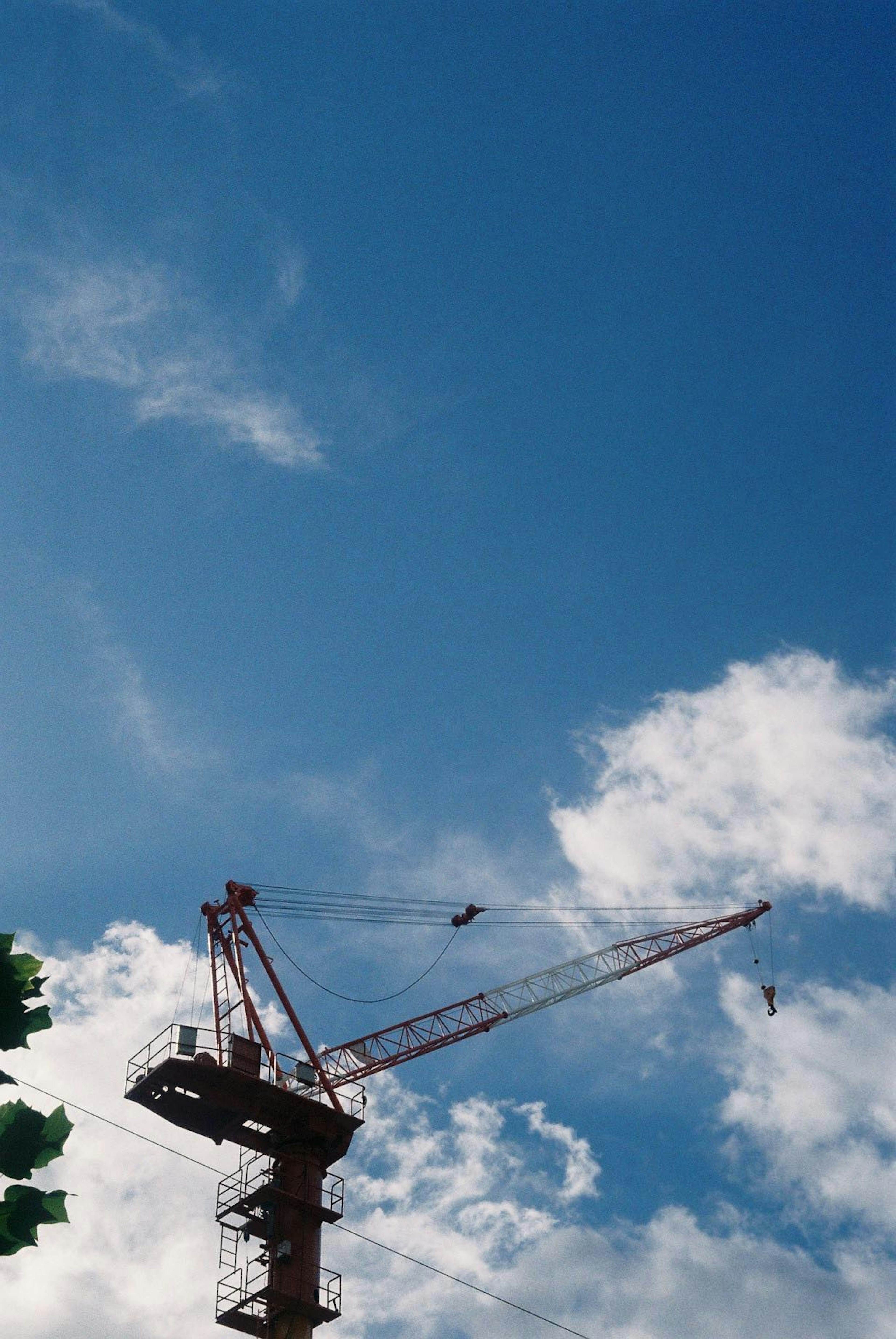 Ein Baukran vor einem blauen Himmel mit Wolken