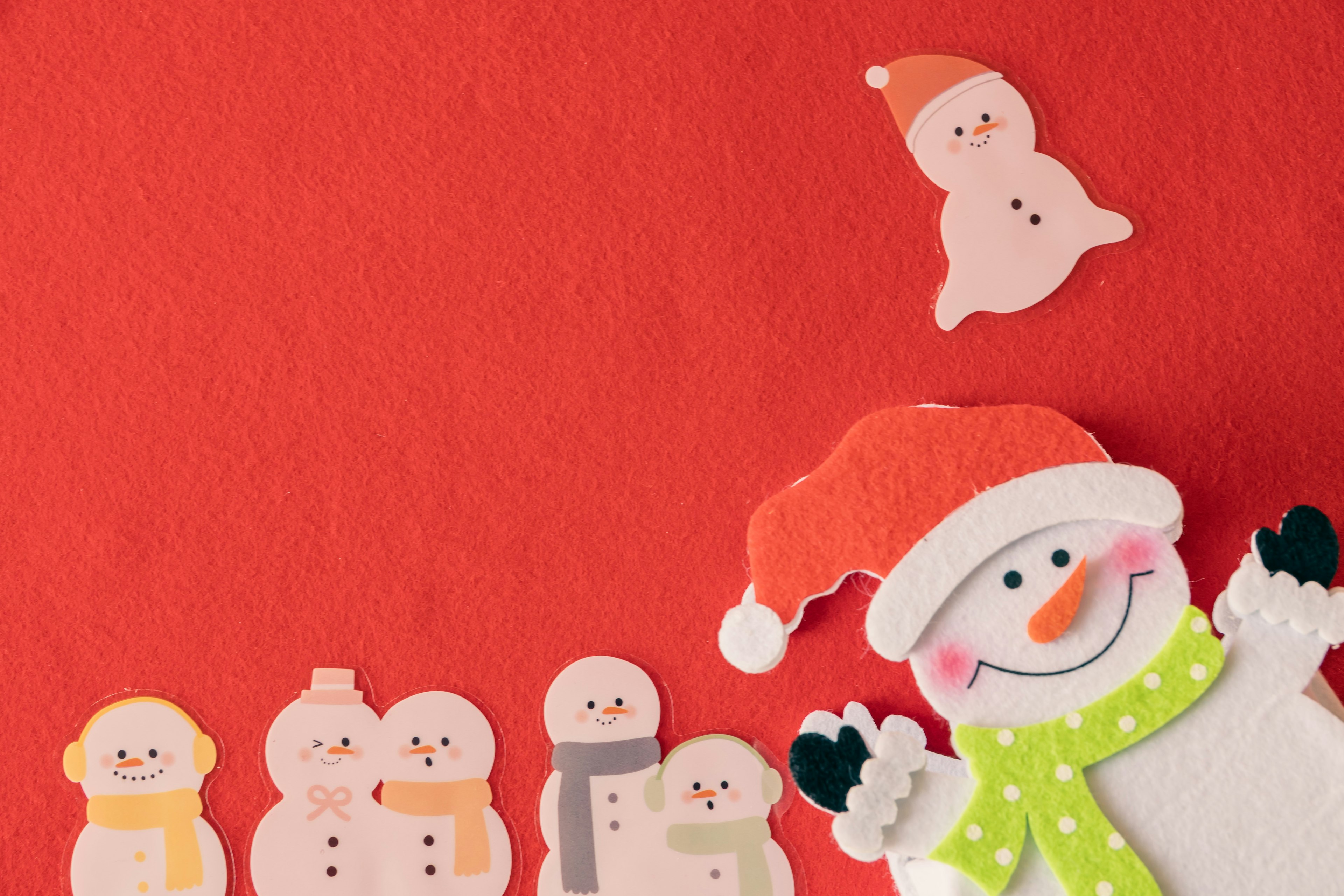 Snowman decorations with a Santa hat on a red background