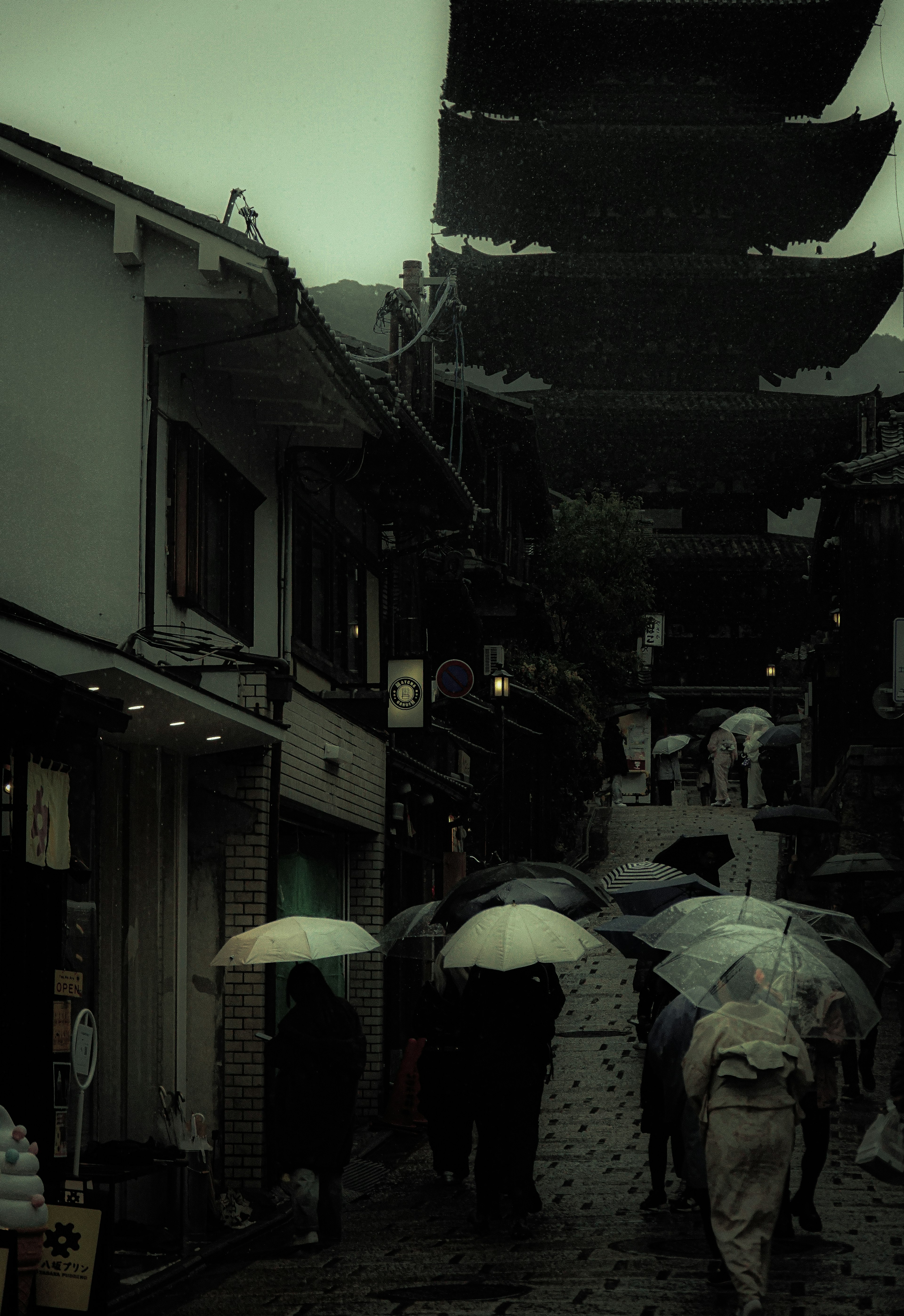 雨の中を歩く人々と傘を持つ景色 古い街並みと伝統的な建物が見える