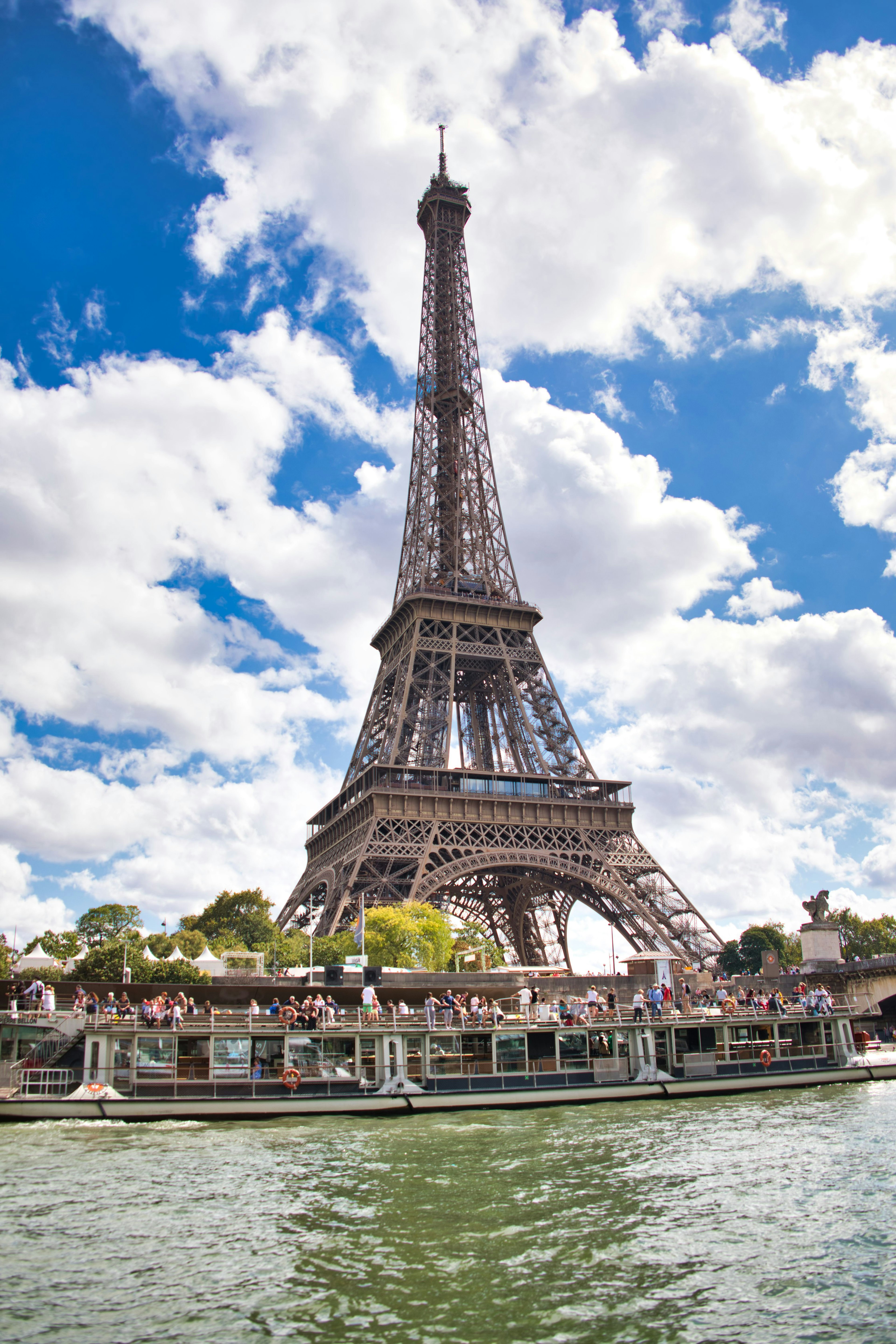 Menara Eiffel dengan langit biru dan awan putih di latar belakang