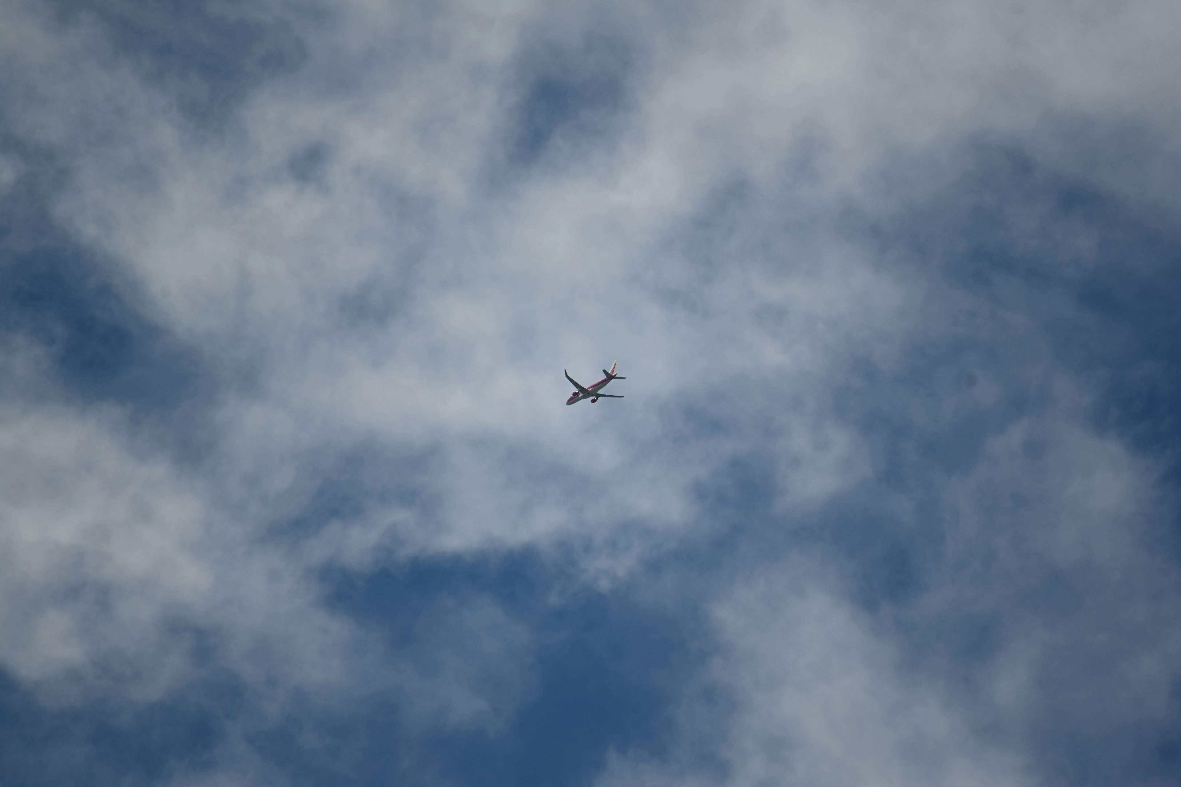 青空に浮かぶ飛行機と雲の風景