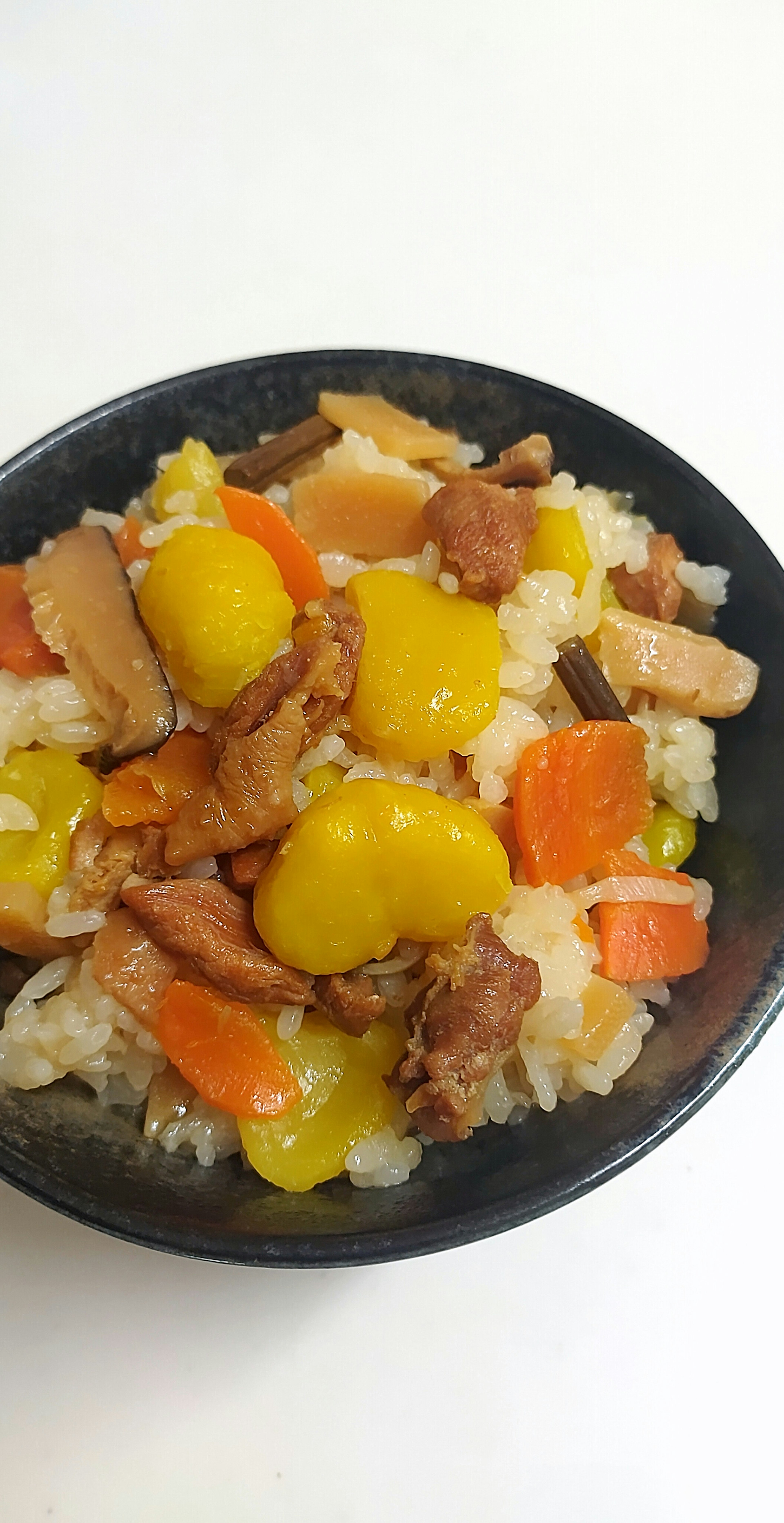 A bowl of colorful rice mixed with vegetables and meat