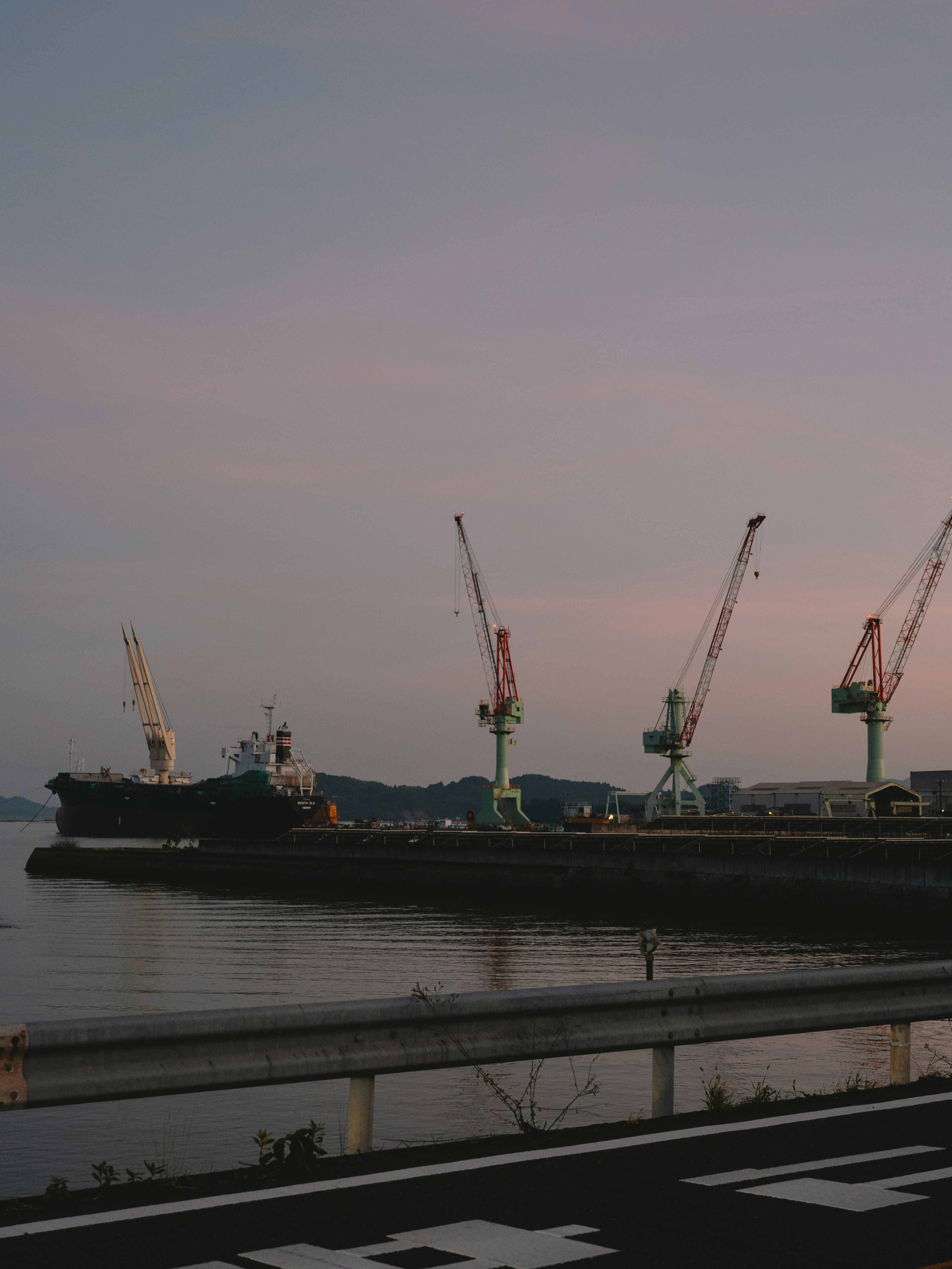 Anochecer en el puerto con barcos y grúas