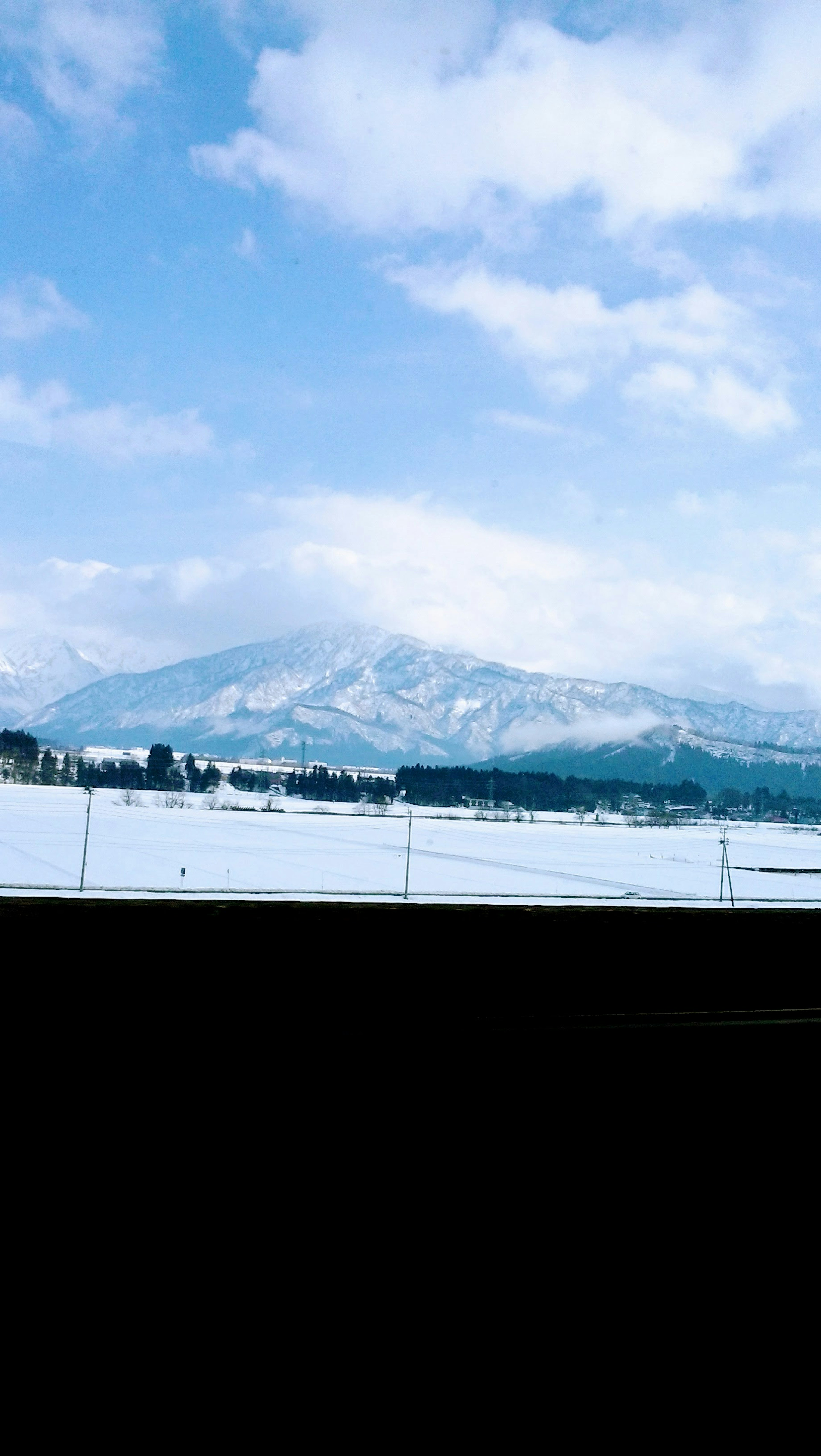 Vista panoramica di montagne coperte di neve sotto un cielo blu