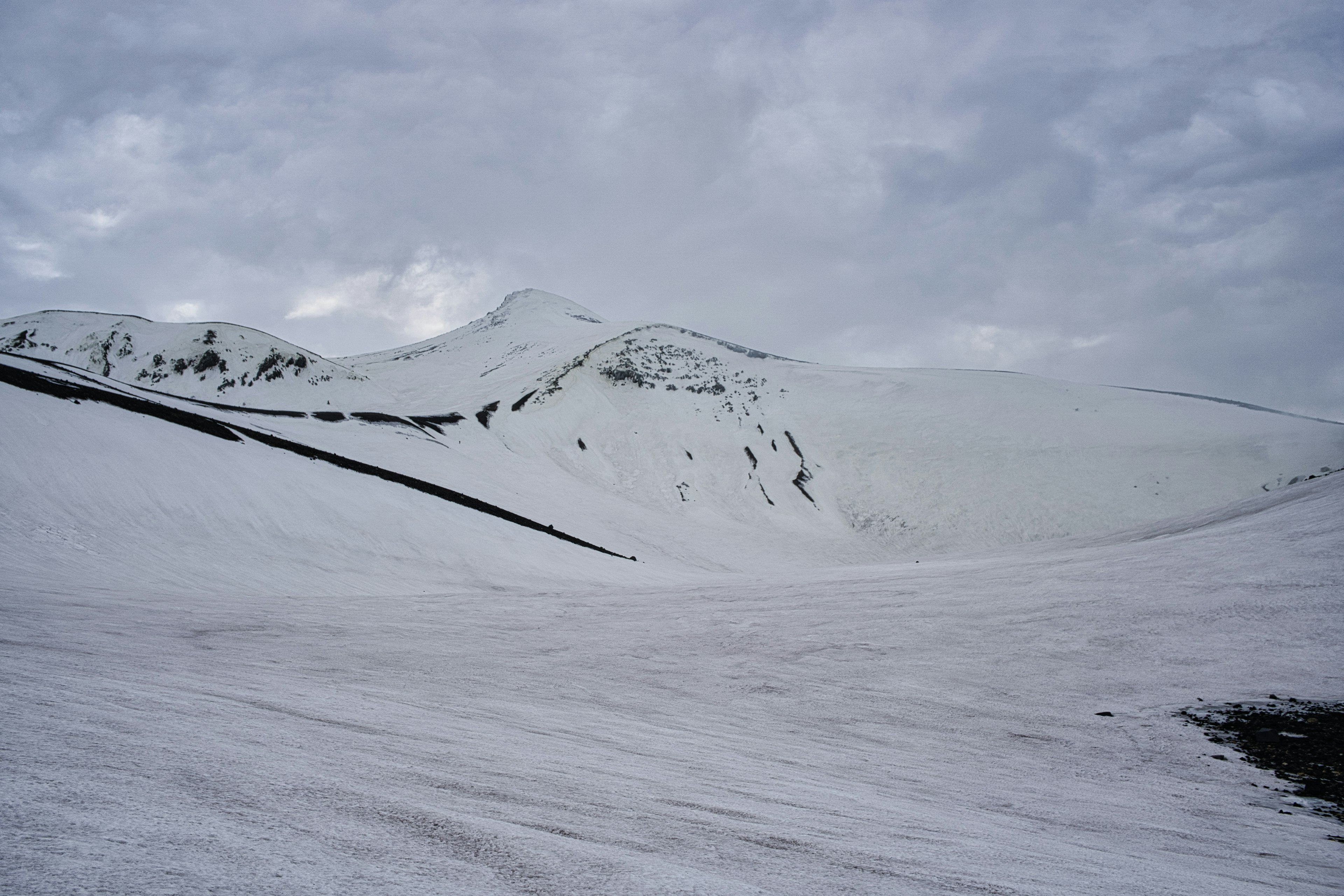 Verschneite Berge unter einem bewölkten Himmel