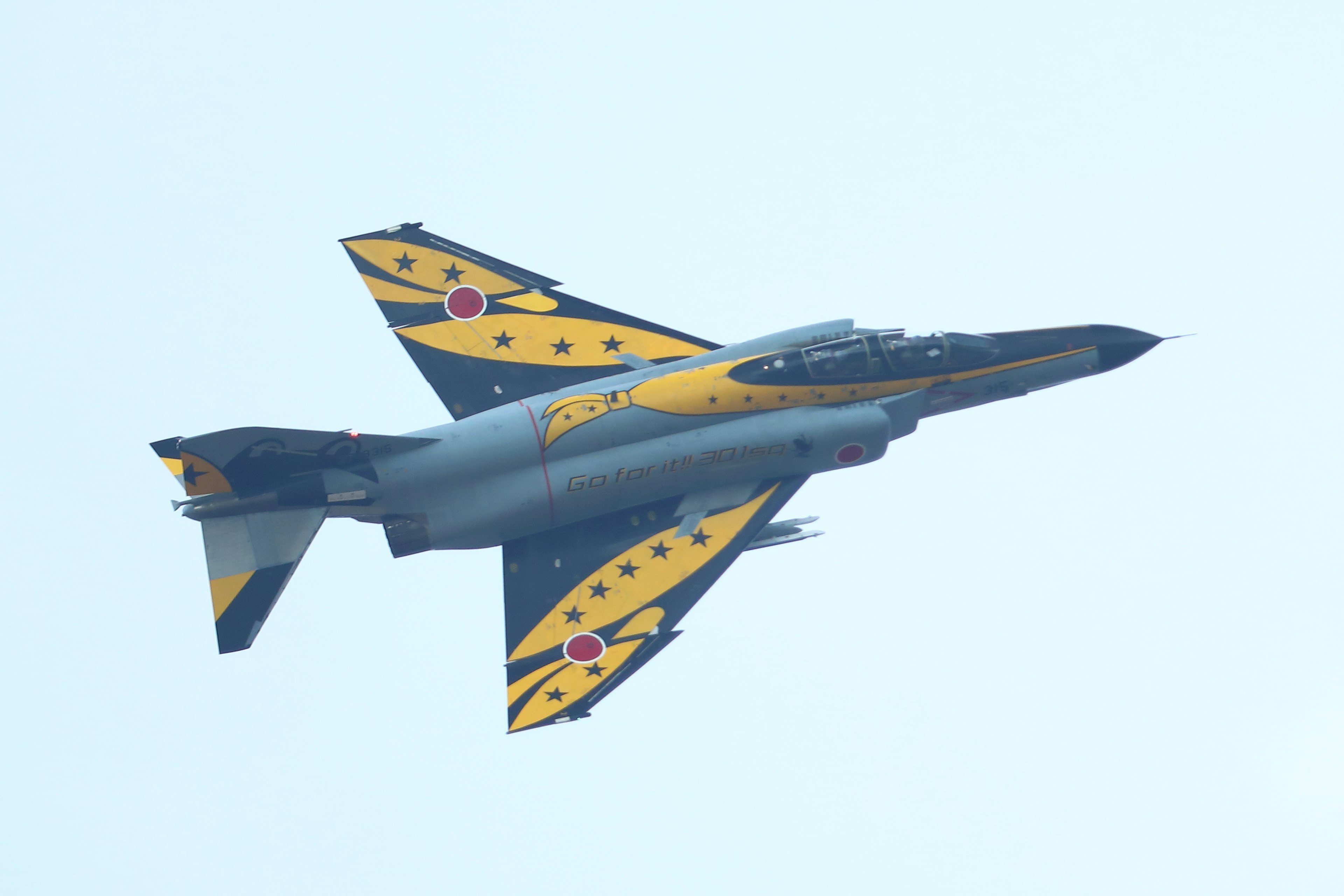 Colorful fighter jet in flight with yellow and black design