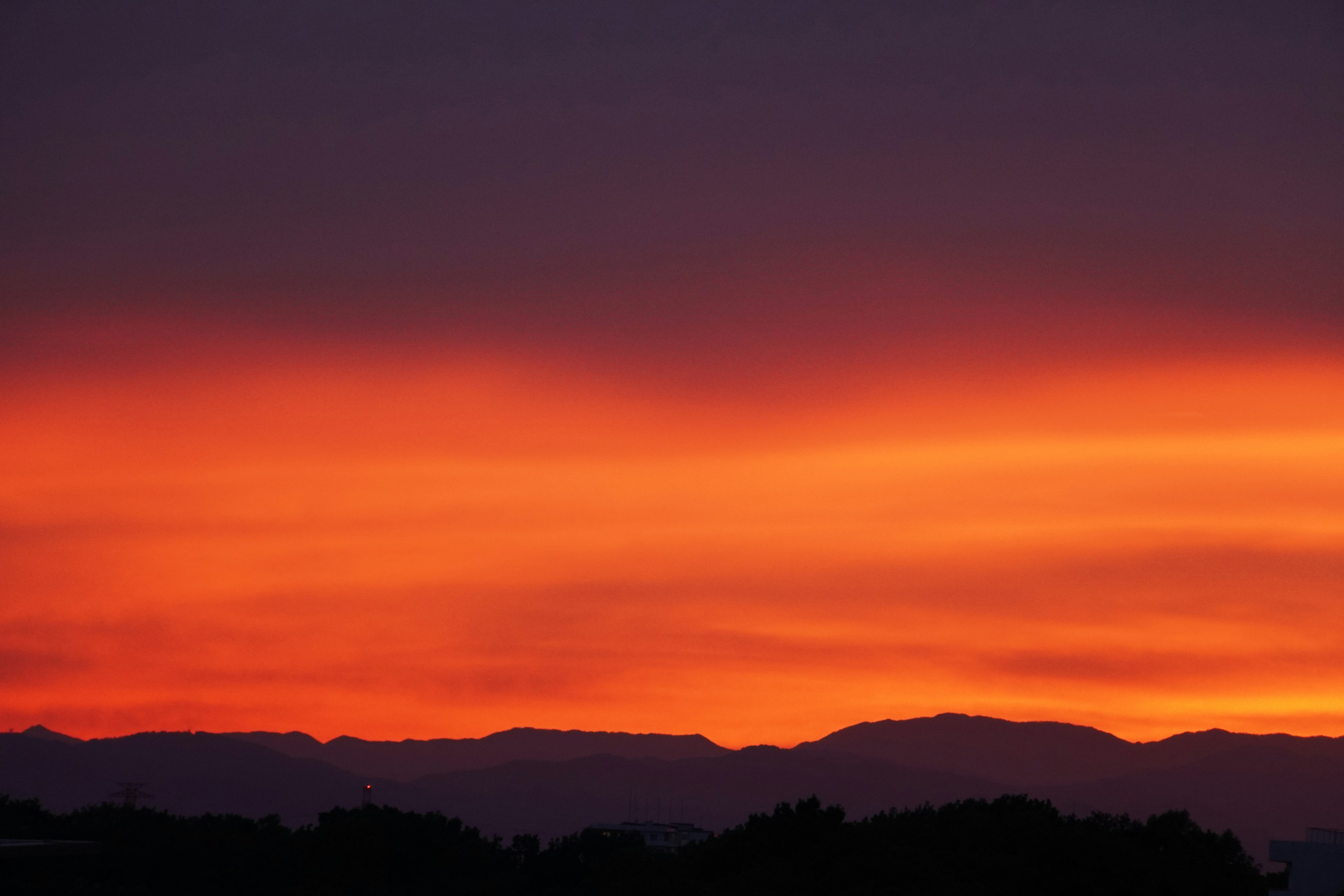 Silhouette of mountains against a vibrant sunset sky