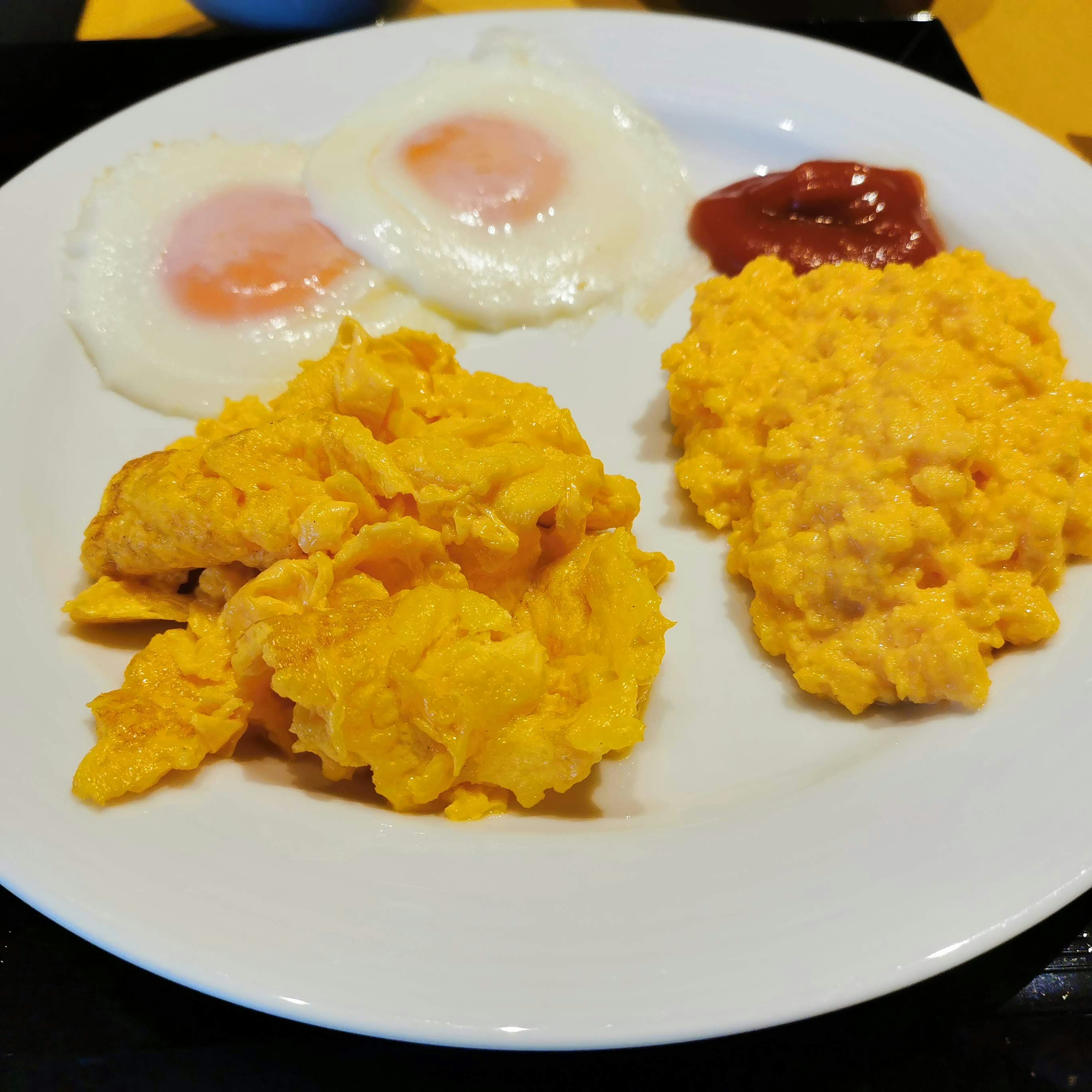 Breakfast on a white plate featuring poached eggs and scrambled eggs