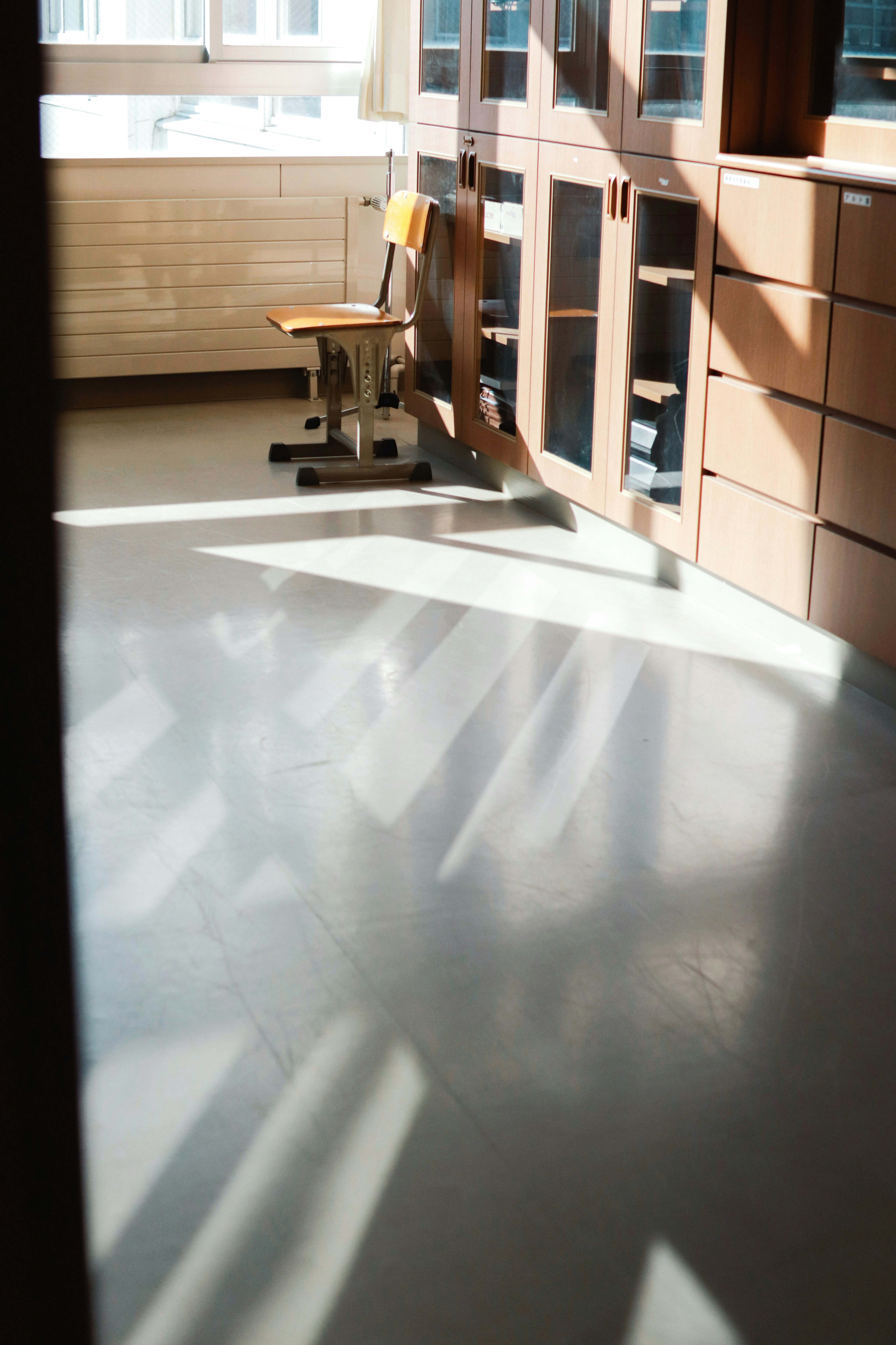 Heller Raum mit Schatten auf dem Boden und einem Holzstuhl