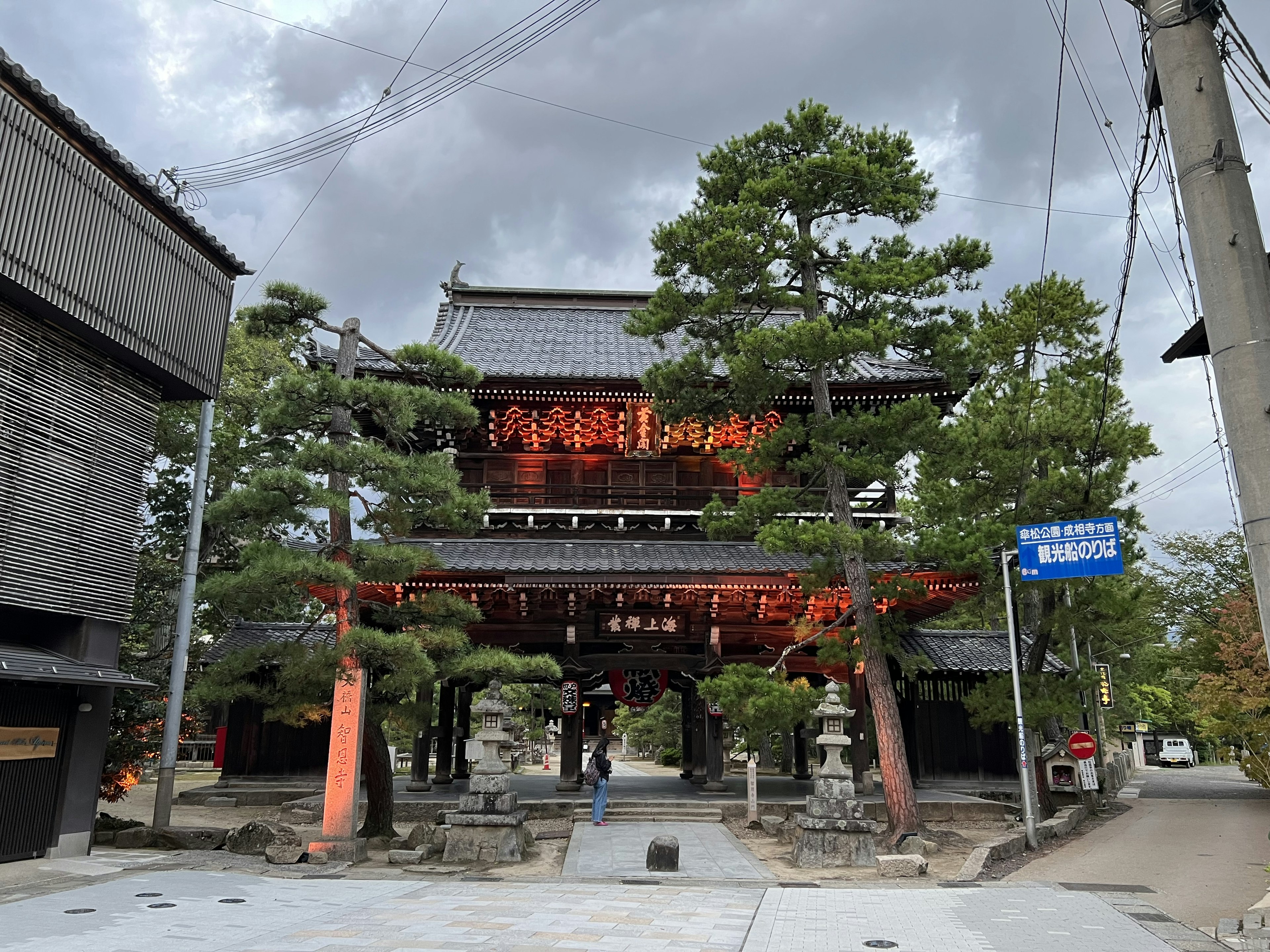 伝統的な日本の寺院の門と緑の松の木がある風景