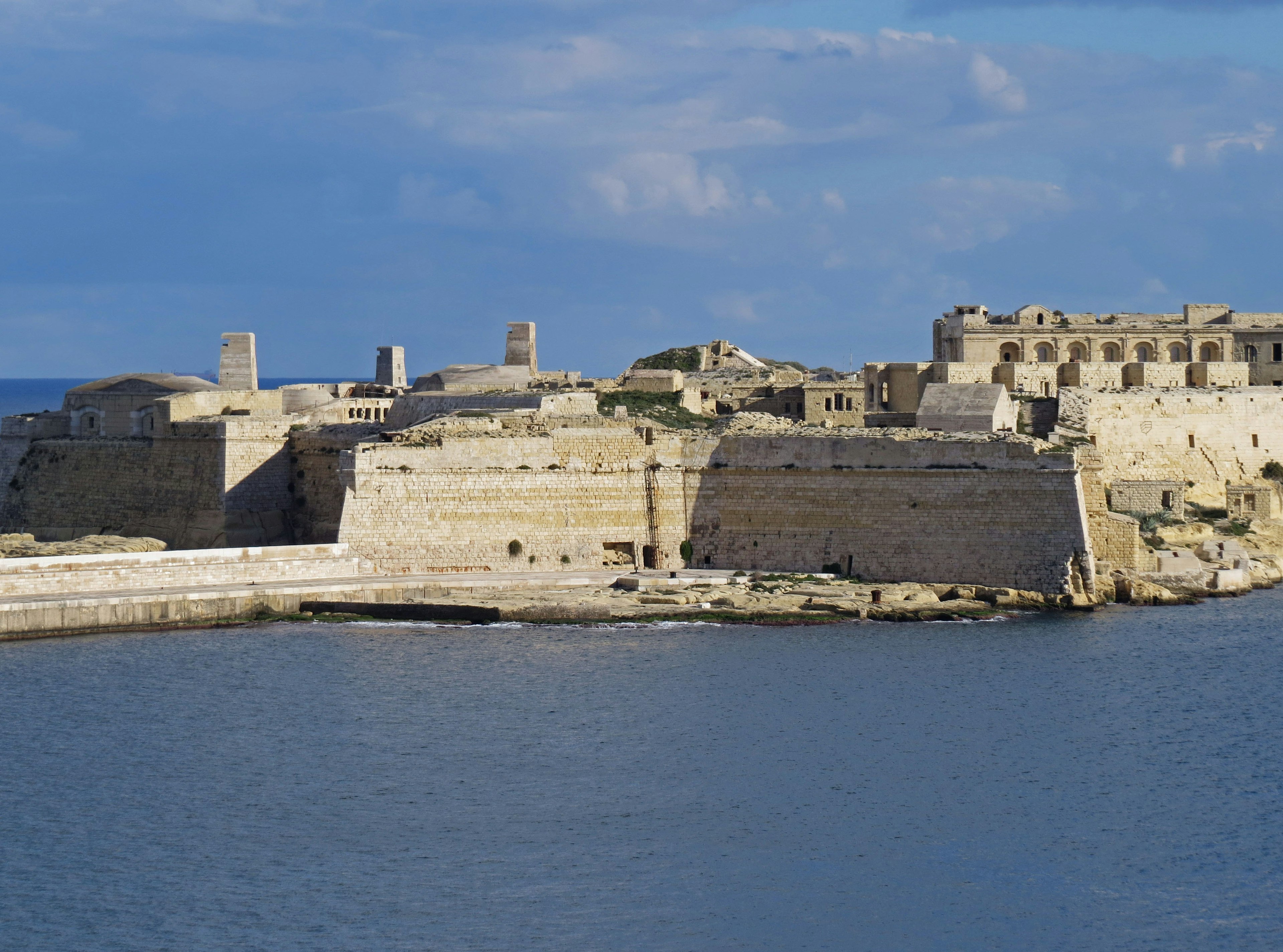 Ruinas de una antigua fortaleza junto al mar bajo un cielo azul